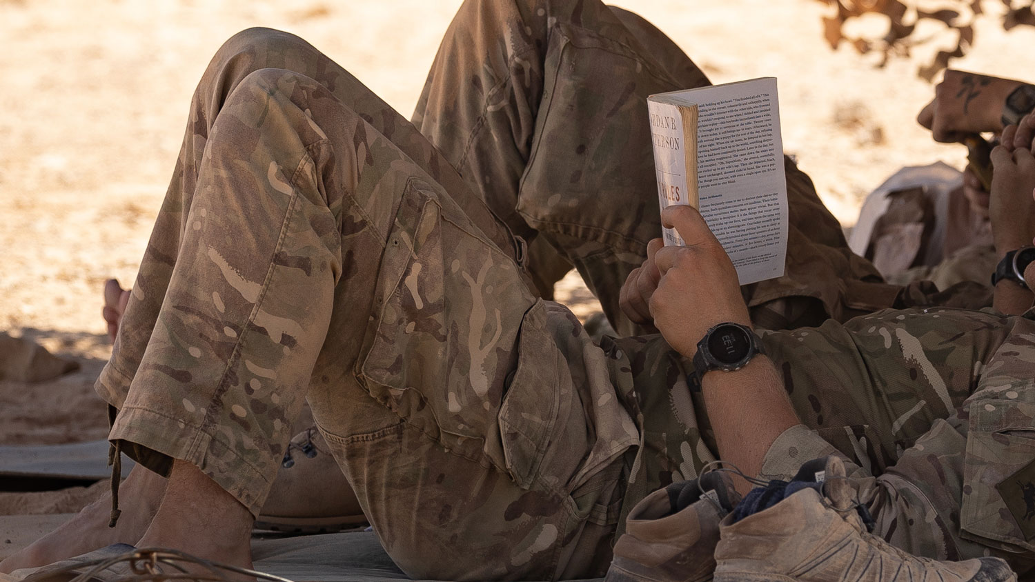 A soldier reads his book during a rest period before a dawn attack on an enemy position (Picture: Crown Copyright).