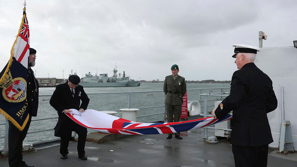 Peter Featherstone Williams, veteran and Chairman of the Bristol Association recieving the white ensign that was lowered for the last time after HMS Bristol's decommissioning ceremony.