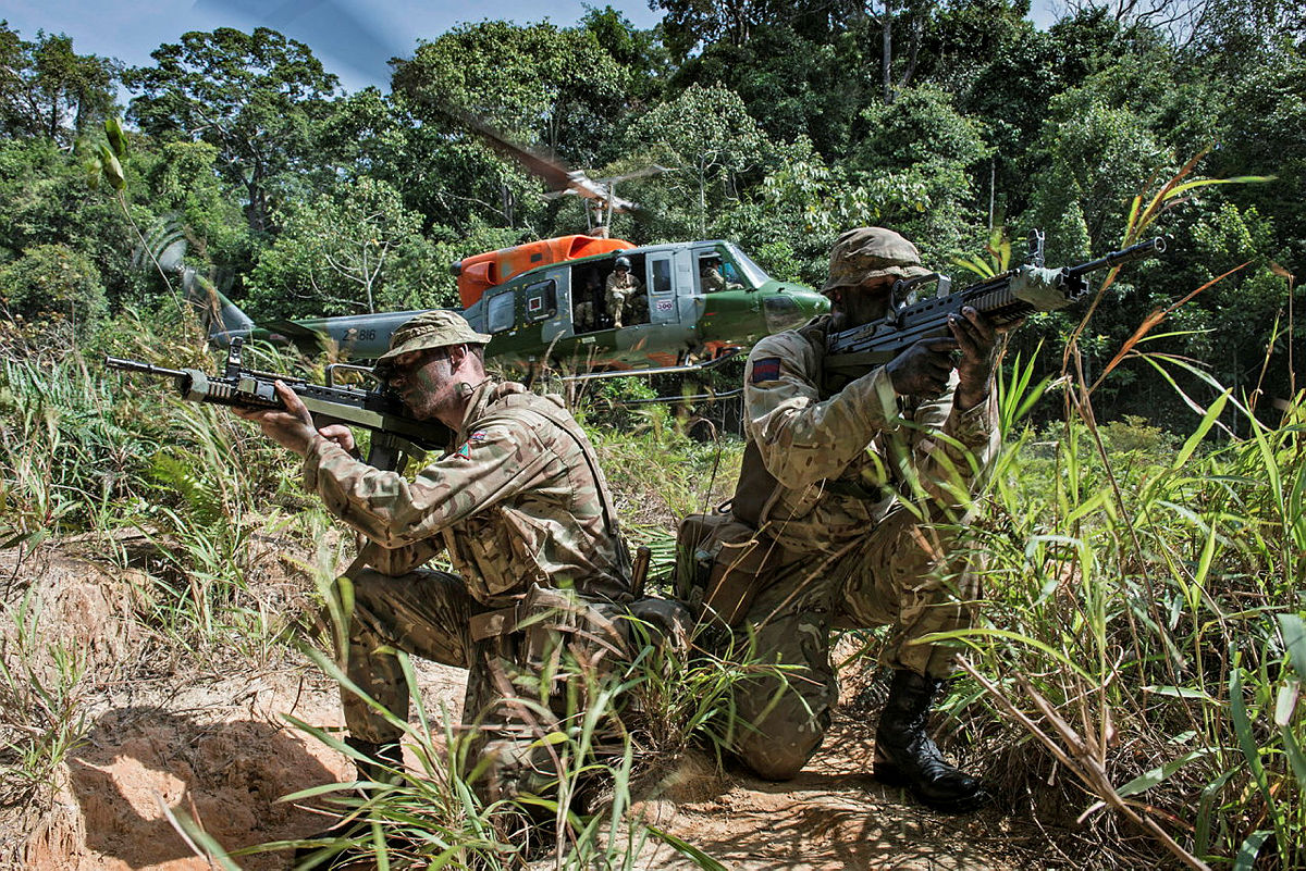 An AAC Bell 212 helicopter seen behind soldiers securing a landing site during Exercise ULU RAJAH in Brunei in 2017 (picture: MOD)