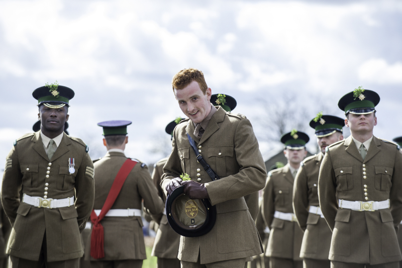 Lieutenant Ollie Wettern, putting a sprig of shamrock on his cap, in anticipation of the arrival of HRH The Duke of Cambridge and The Duchess of Cambridge.