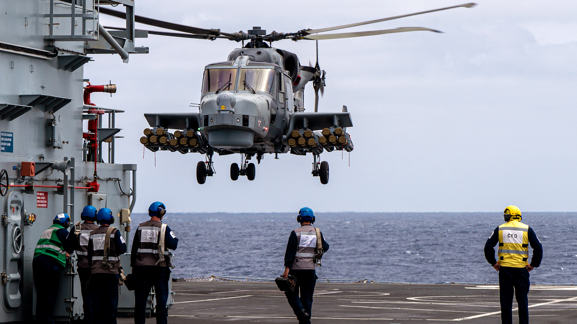 Aircraft handlers watch the Wildcat fully armed with 20 Martlets during sea trials