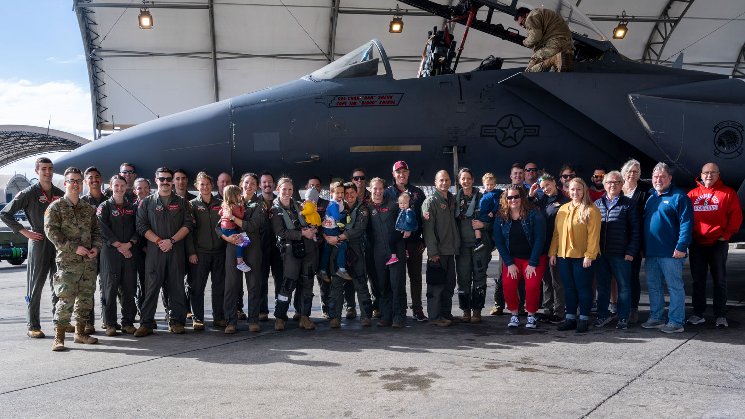USAF pilots assigned to the 4th Fighter Wing, along with family and friends, pose for a group photo after Maj McElroy completed her final flight at Seymour Johnson Air Force Base, North Carolina in November 2022 CREDIT US Air Force AND Senior Airman Kylie Barrow