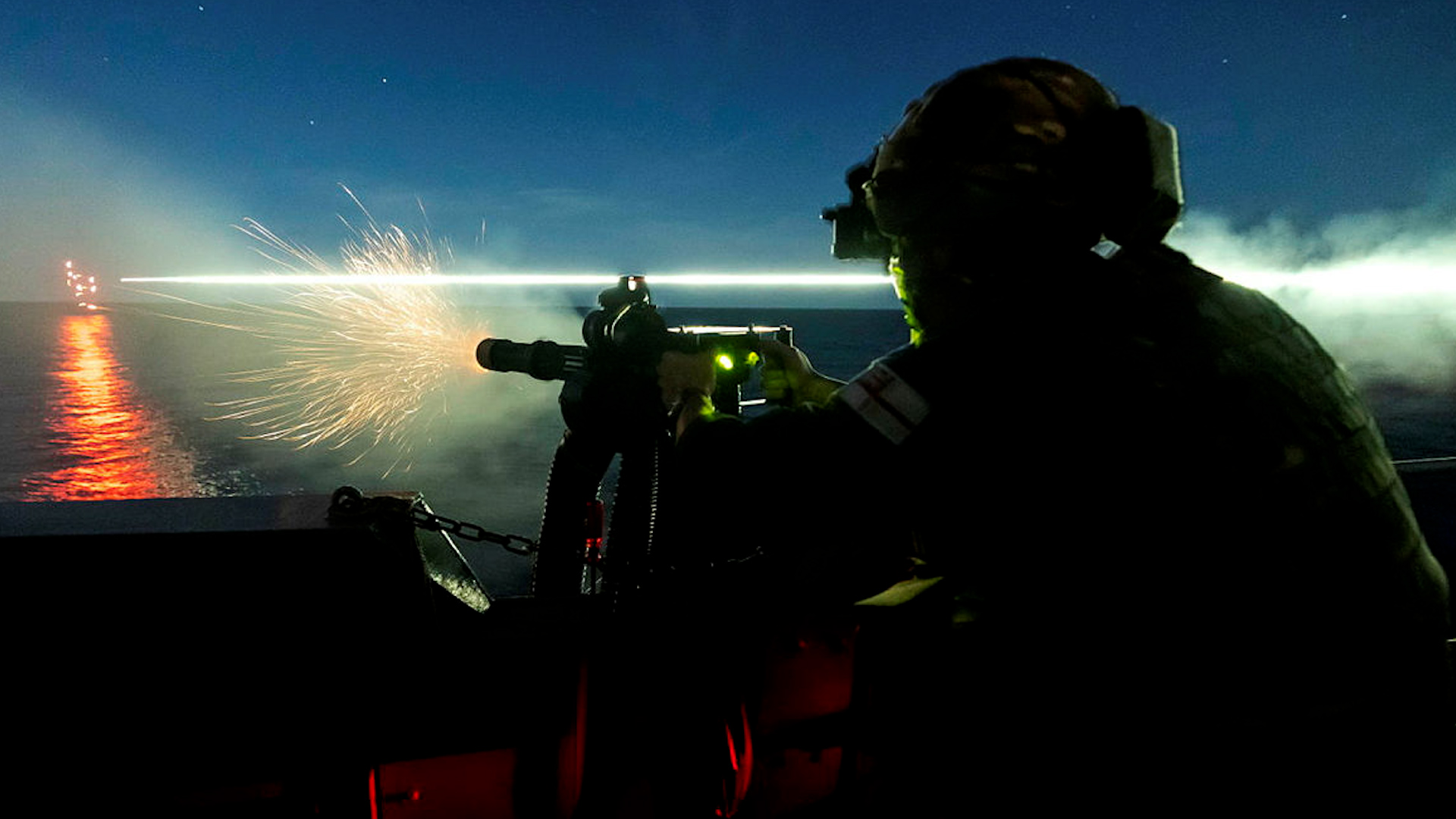 Anonymous sailor on HMS Kent takes part in a night time gunnery serial in the Philippine Sea (Picture: MOD).