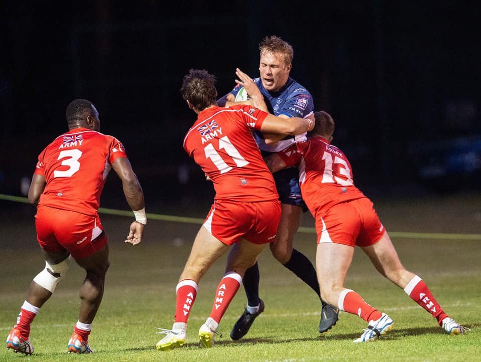 A Navy player is stopped in his tracks by the Army (Picture: SBS Photography).