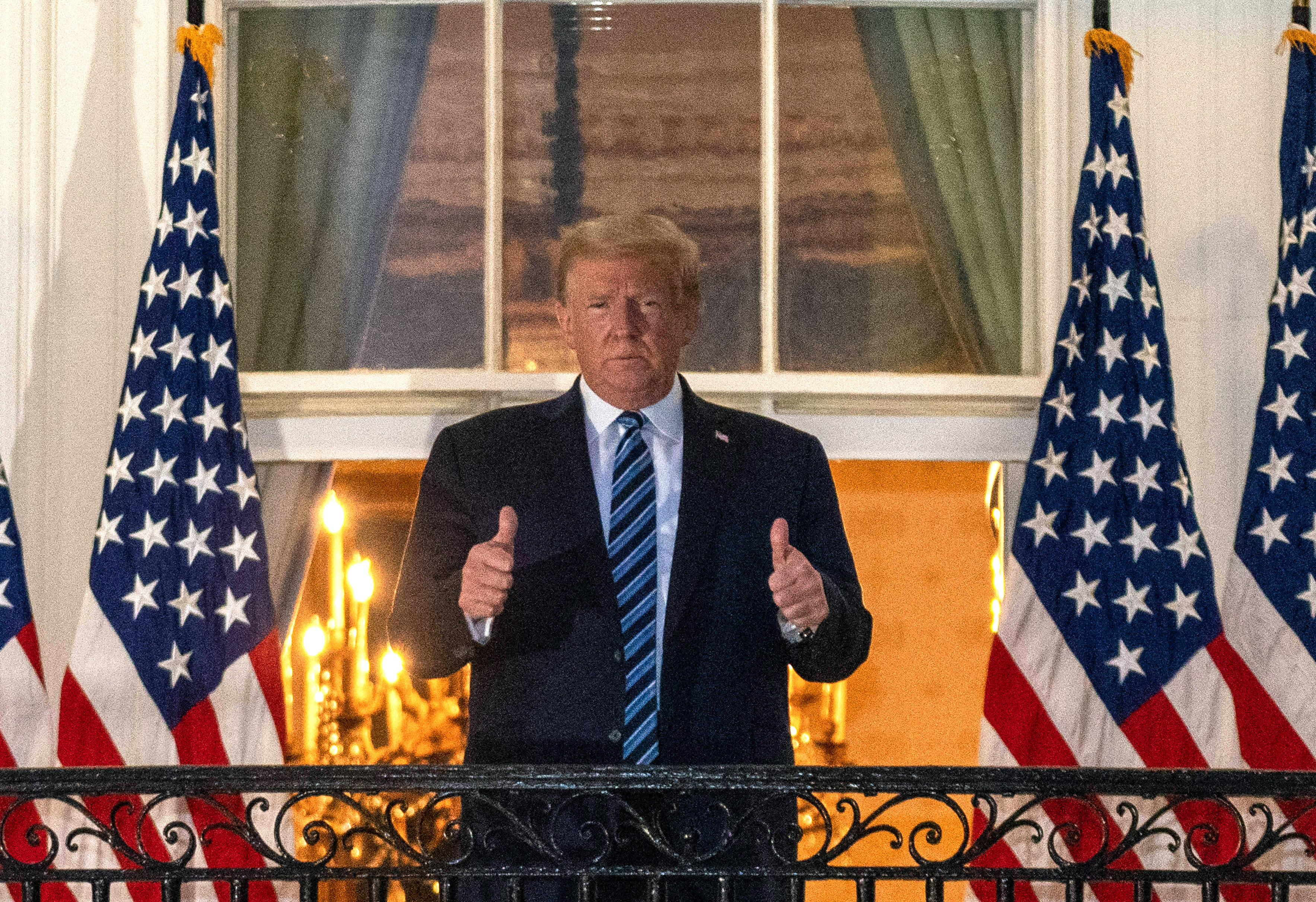 Cover image: Mr Trump gives a double thumbs-up after arriving back at the White House (Picture: PA).
