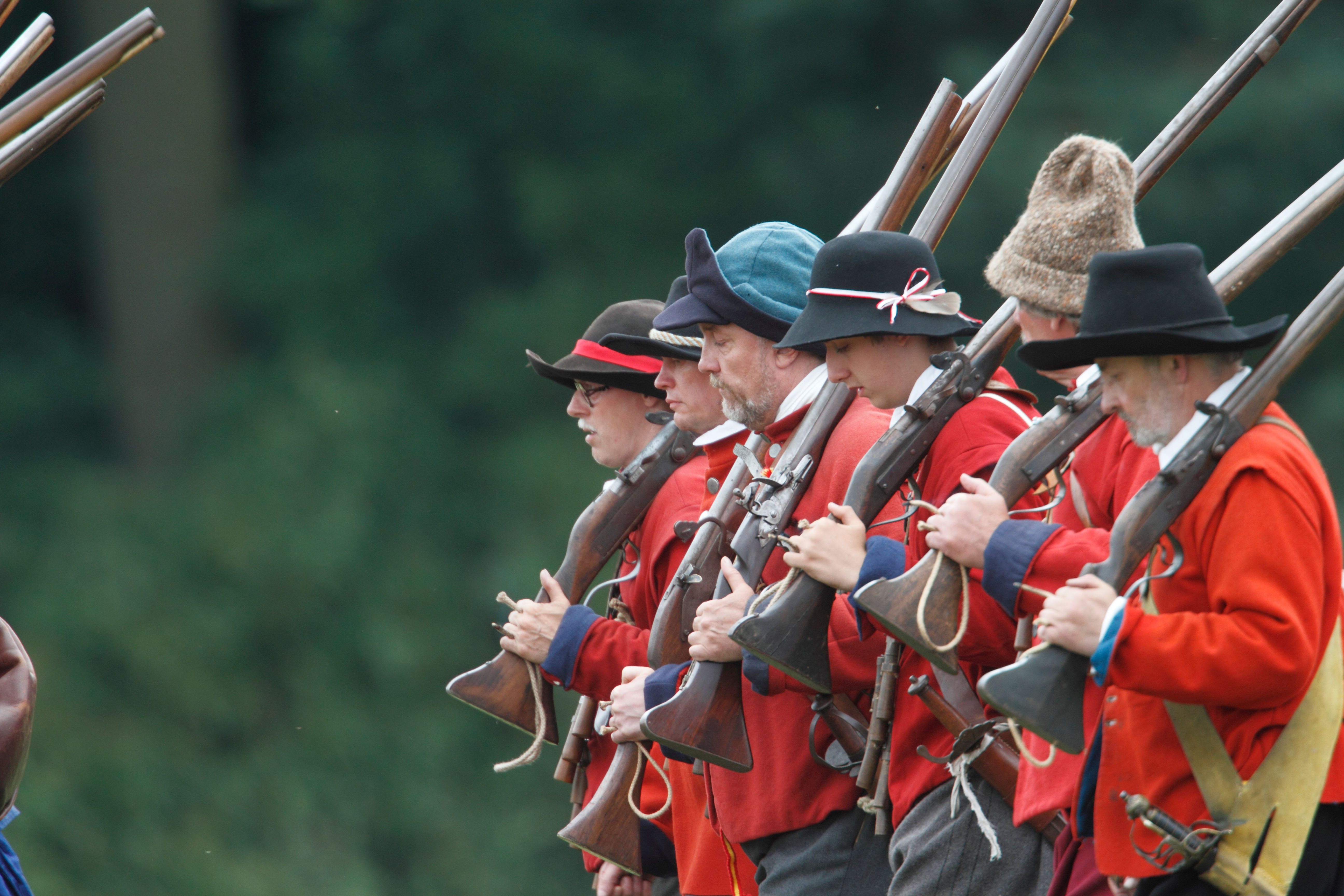 English Civil War re-enactors in red coats and with muskets