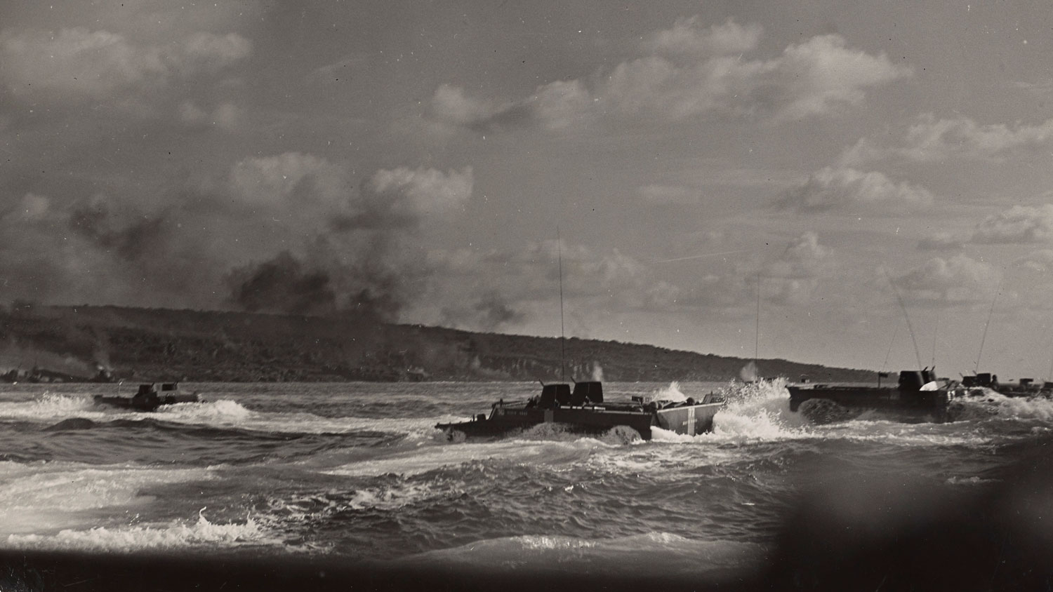 Black smoke is seen over the shores of Iwo Jima as the fifth assault wave of Marines lands on the island CREDIT National Archives and Records Administration