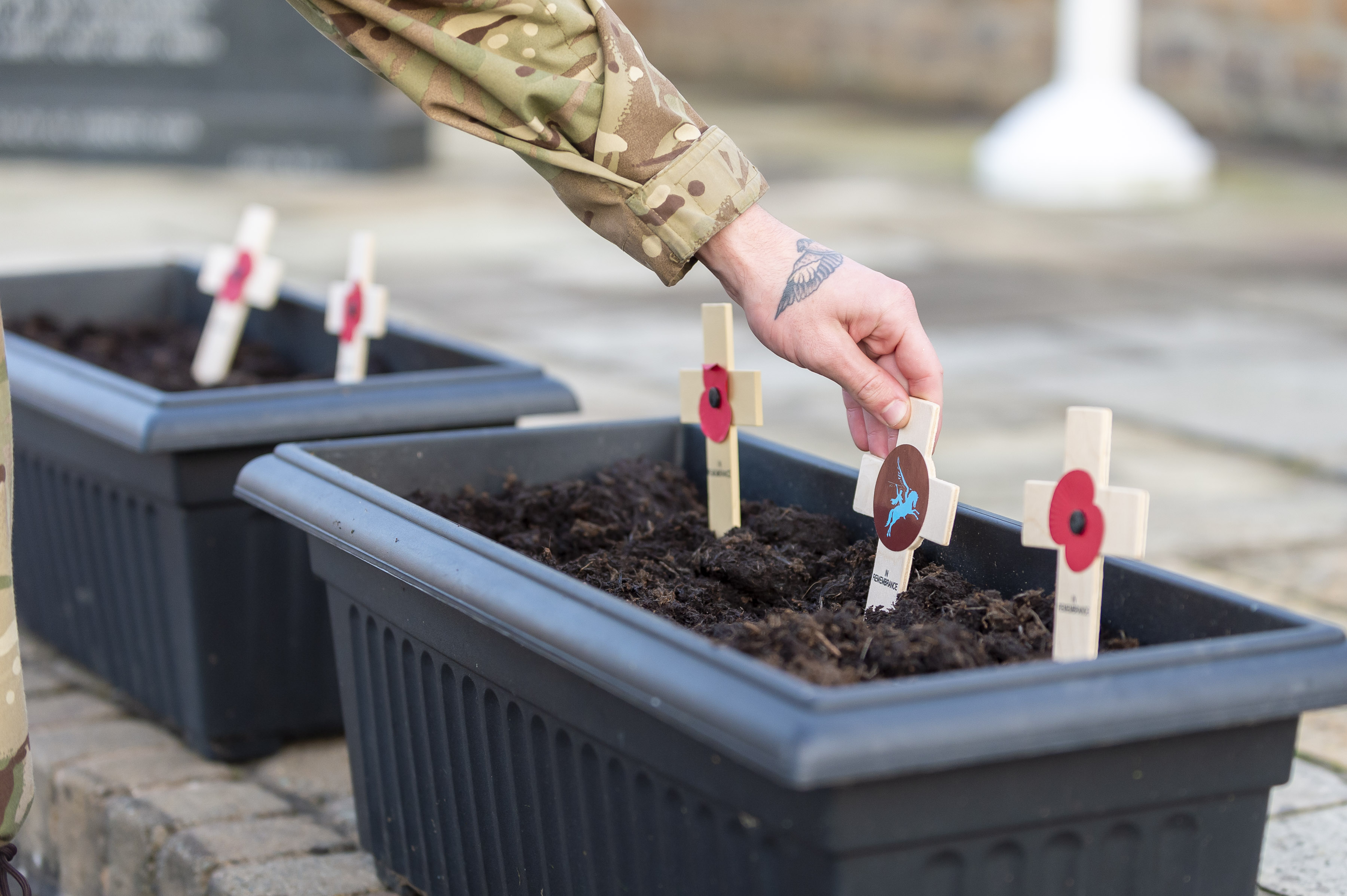 British Army soldier planting a poppy cross 