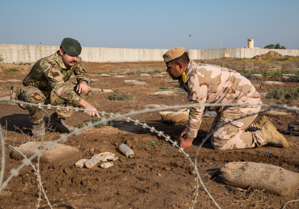 British Army trainer teaches Iraqi soldier in counter-IED training at Camp Taji