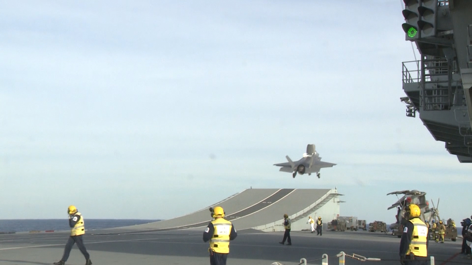 A jet takes off from the aircraft carrier's ski ramp.