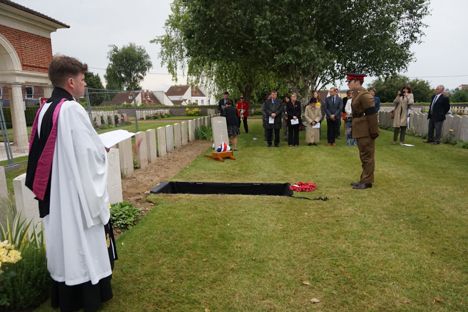 Capt David Hughes, lays a wreath at a graveside