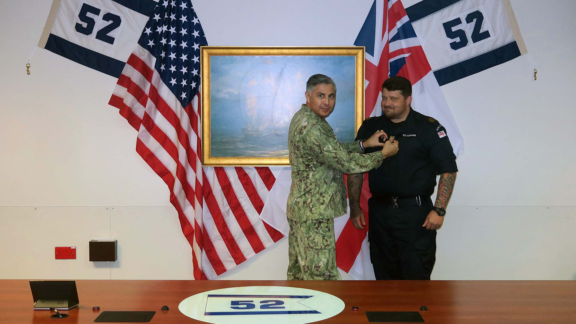Capt Oscar Rojas CO of CTF52 pins the NAM Medal on CPO Flash Gordon CREDIT ROYAL NAVY.png