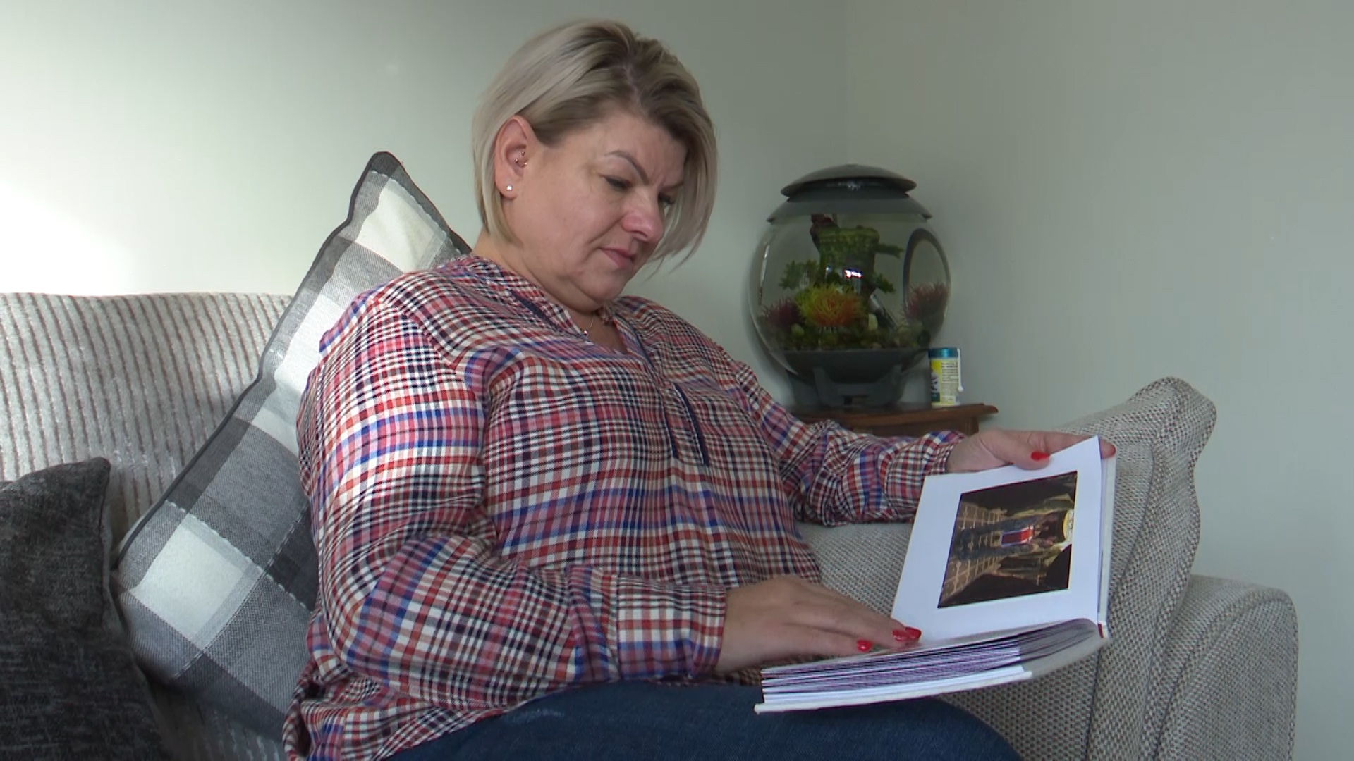 Captain Dean Sprouting's wife Linda looks through a family photo album