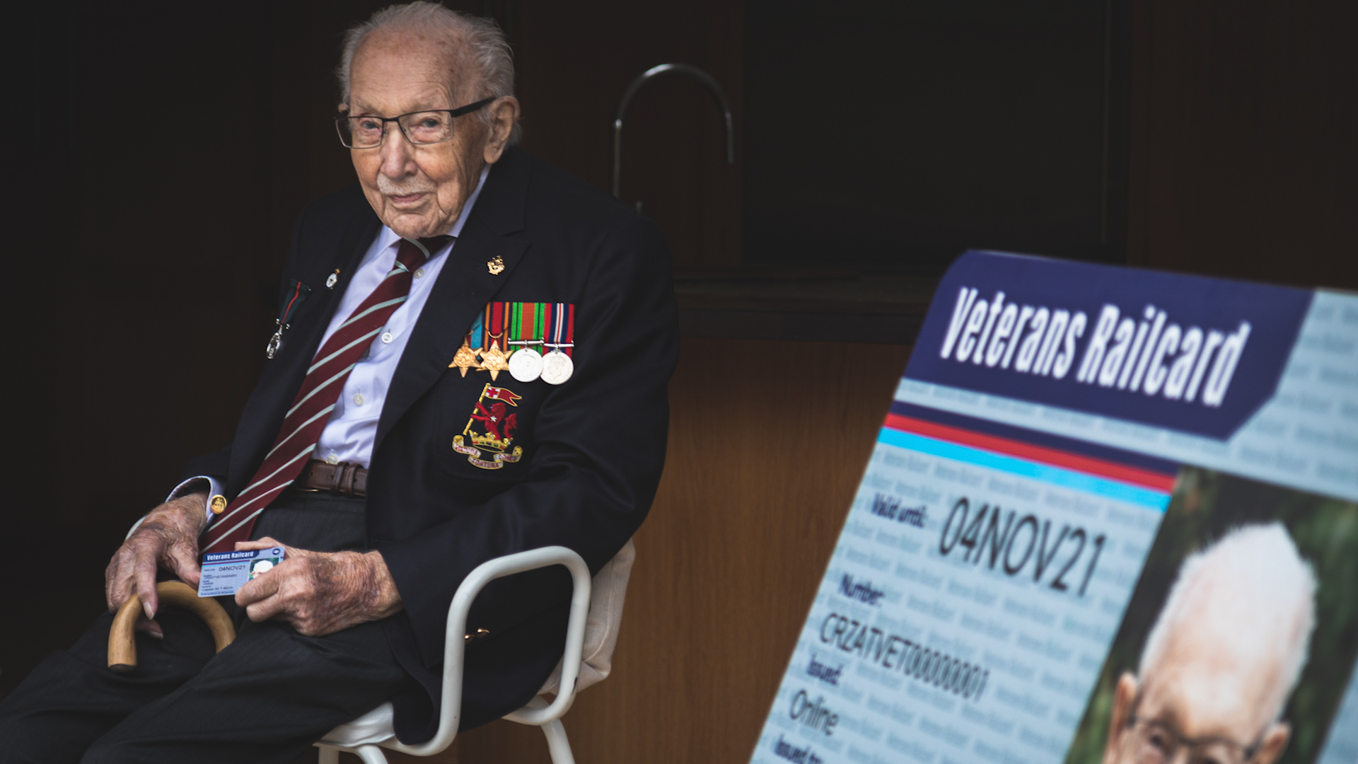 Captain Sir Tom Moore sits holding first ever veterans Railcard 131020 CREDIT Department of Transport.jpg 
