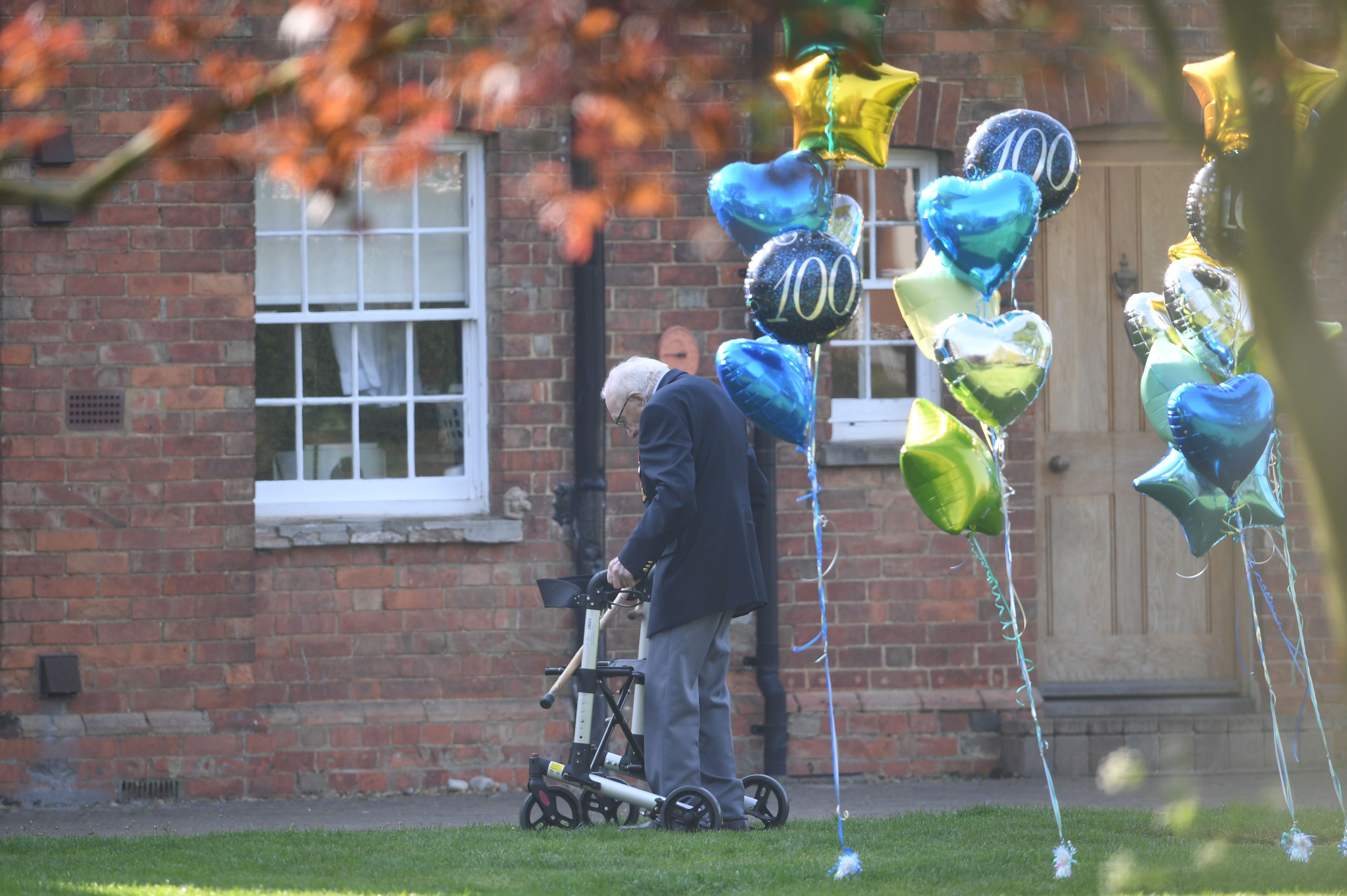 Captain Tom Moore with balloons outside his Bedfordshire home