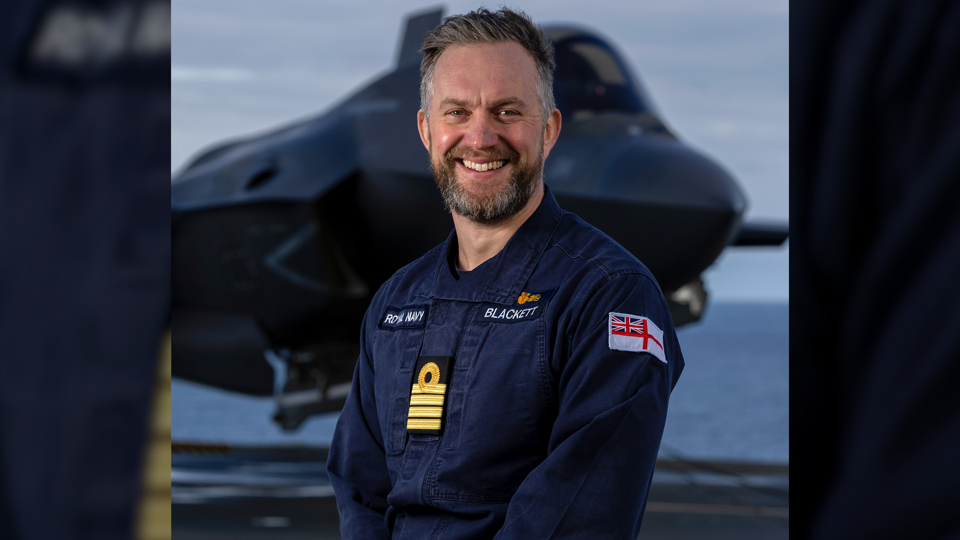 Captain of HMS Prince of Wales Captain Will Blackett standing in front of F-35 aircraft CREDIT Royal Navy.jpg