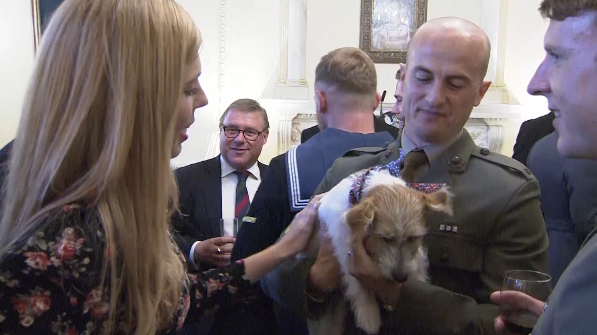 Carrie Symonds, partner of the Prime Minister (left), shows off their Jack Russell dog Dilyn to personnel.