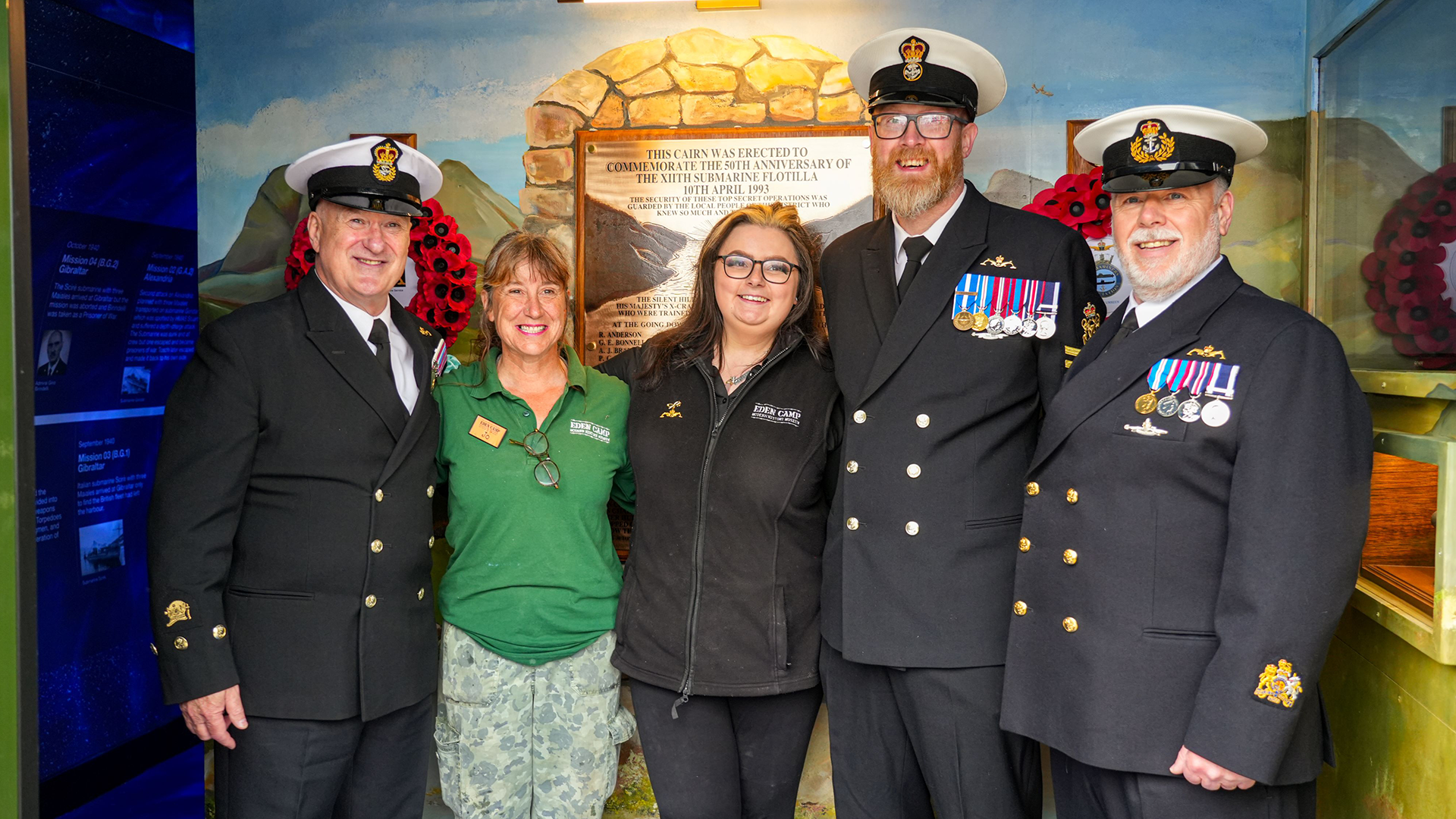 Chief David O’Neill, Jo Claire – Maintenance Eden Camp (artist of the backdrop), Summer O’Brien – Collections and Engagement Manager Eden Camp, PO Paul Hogg, and WO1 Mark Harris CREDIT Royal Navy