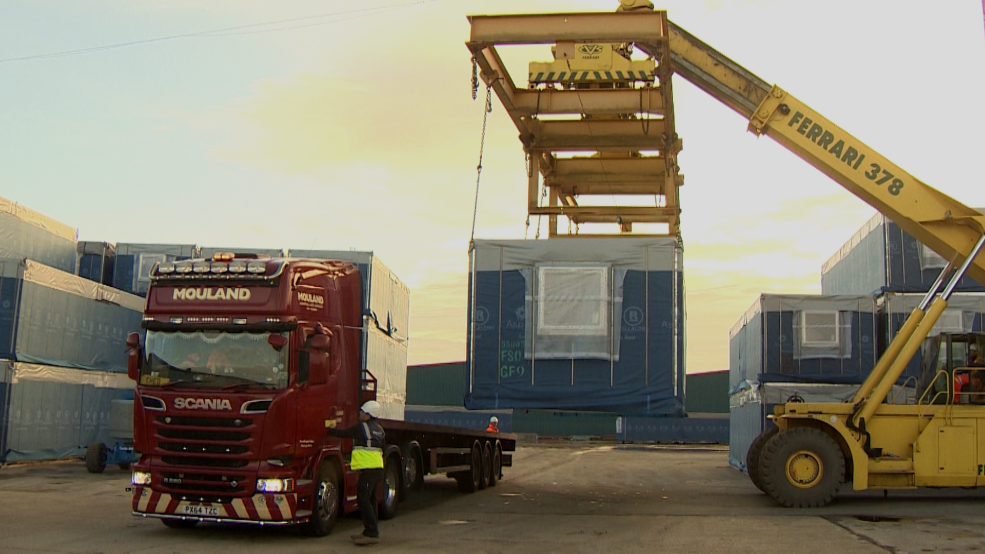 Completed single-room unit is hoisted onto truck 