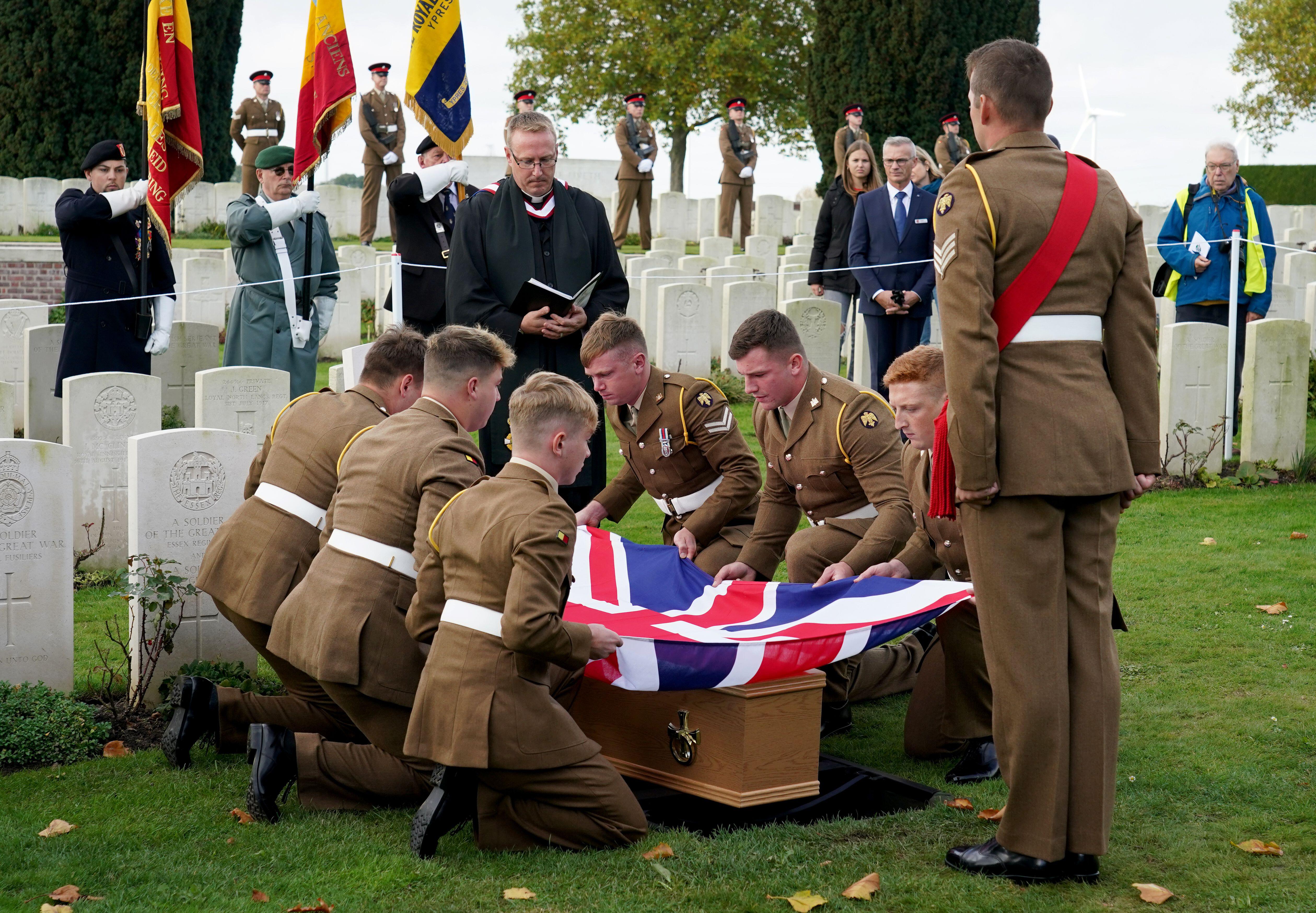 Coffin of Lance Corporal Robert Cook, who died in WW1, is carried in to the Commonwealth War Graves Commission's (CWGC) New Irish Farm Cemetery near Ypres in Belgium