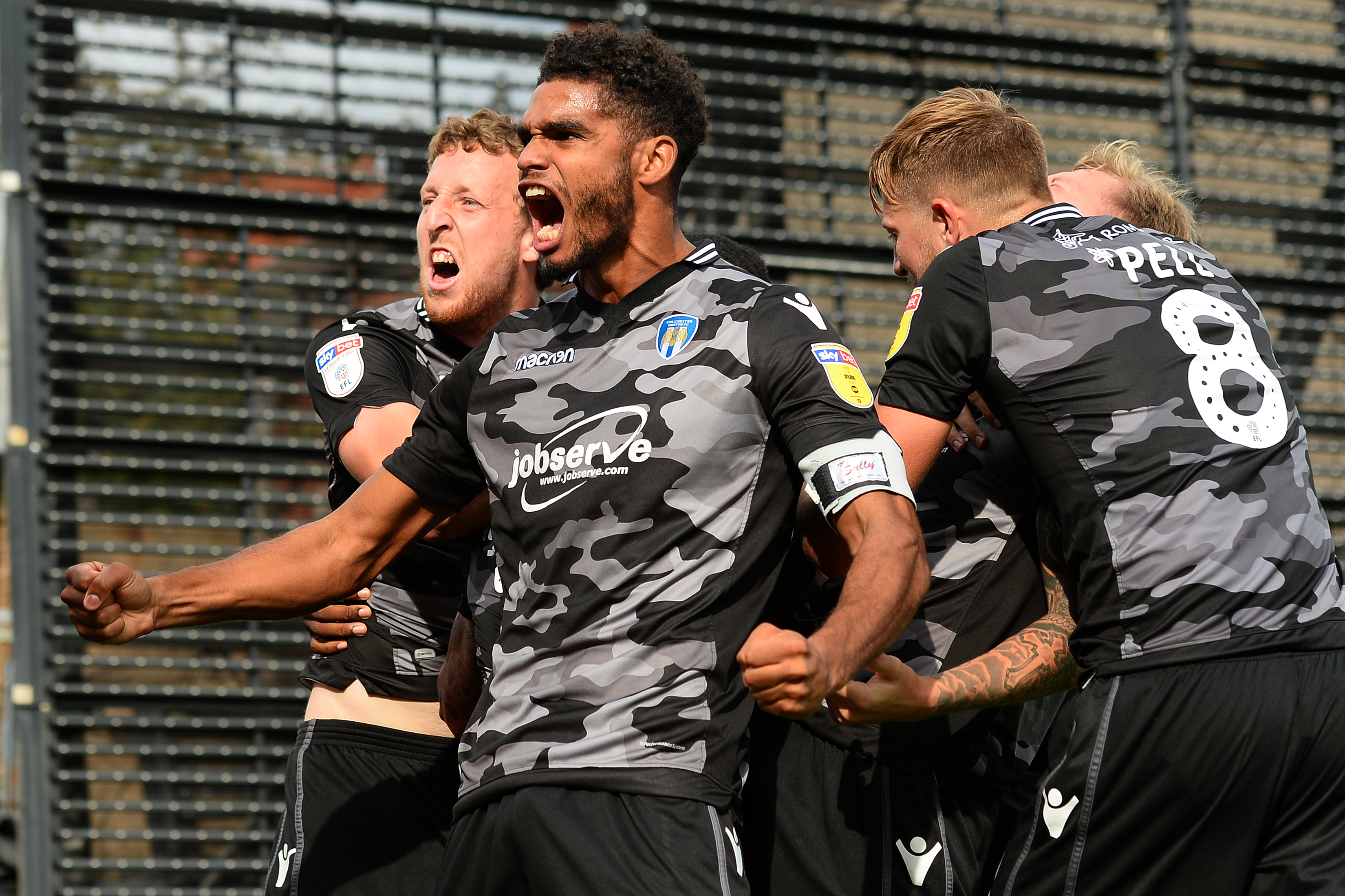 Colchester United players celebrate a last-gasp equaliser against Mansfield Town in their camo away kit (Picture: Colchester United).
