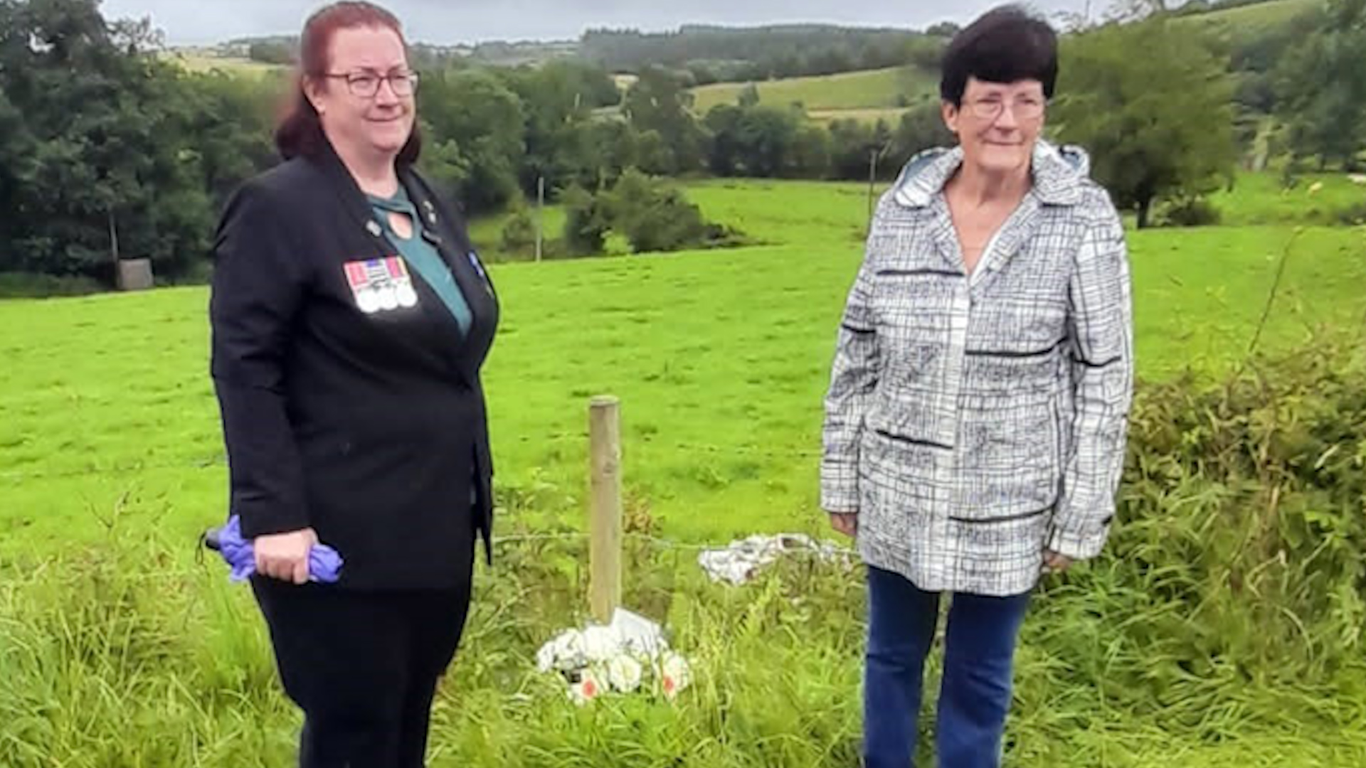 Cpl Criddle's daughter Sarah Criddle (left) and his widow Julia Wilson laying flowers at the scene where he was fatally injured in Clogher in 1973 23072023 NO REUSE CREDIT PA WIRE, PA IMAGES