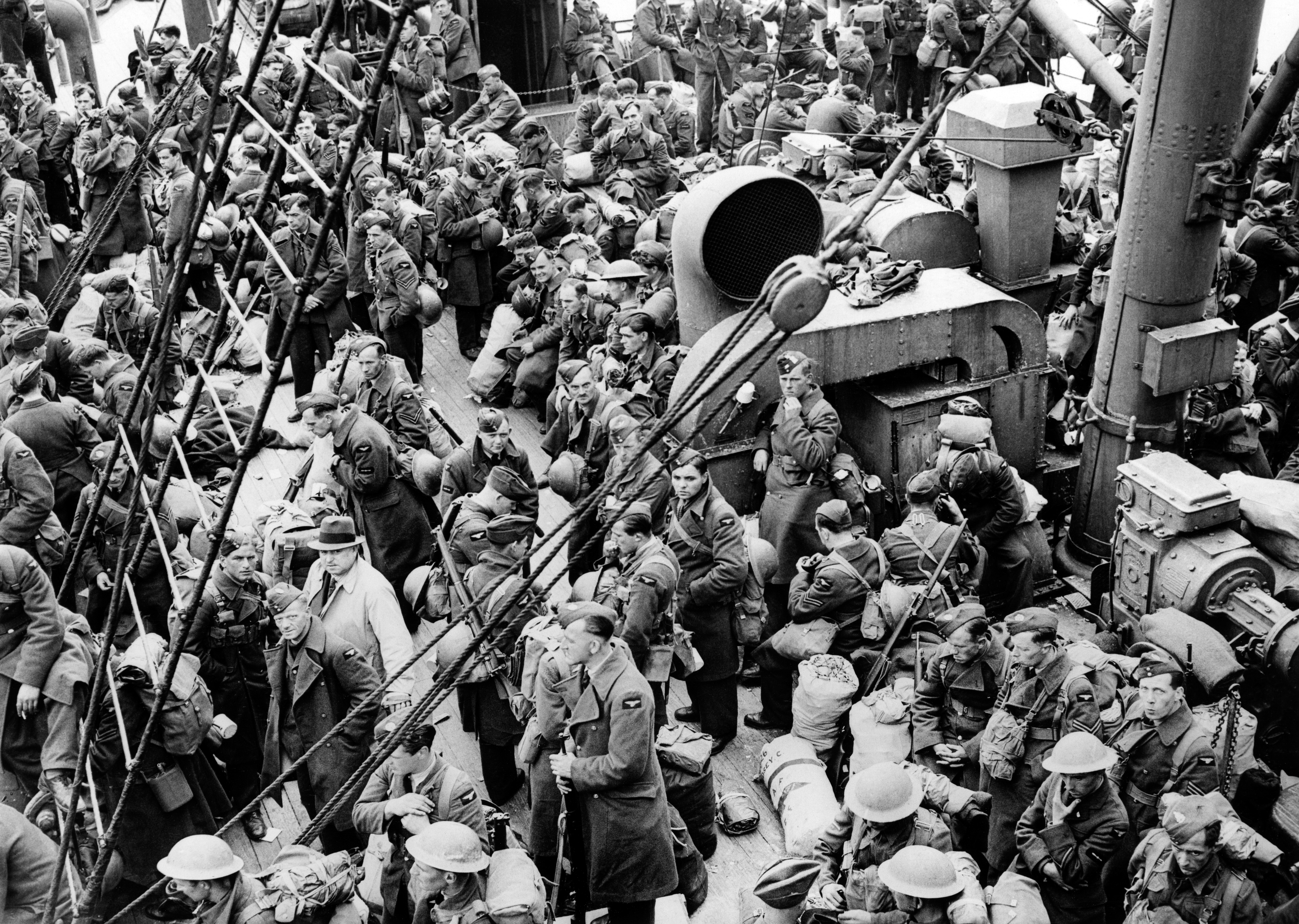 RAF airmen crowd the deck of a steam Boat during Operation ARIEL