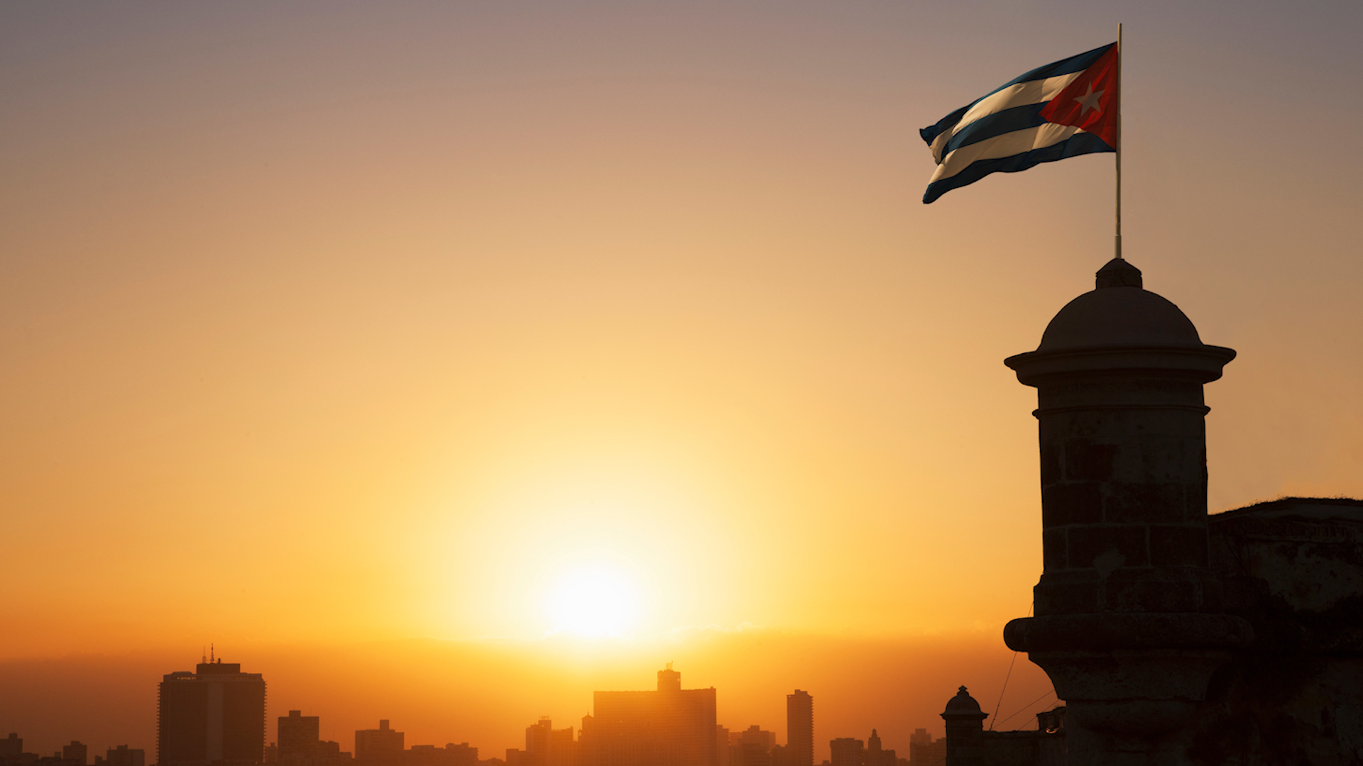 Cuban flag over the Fortress of El Morro at sunset, Havana, Cuba 