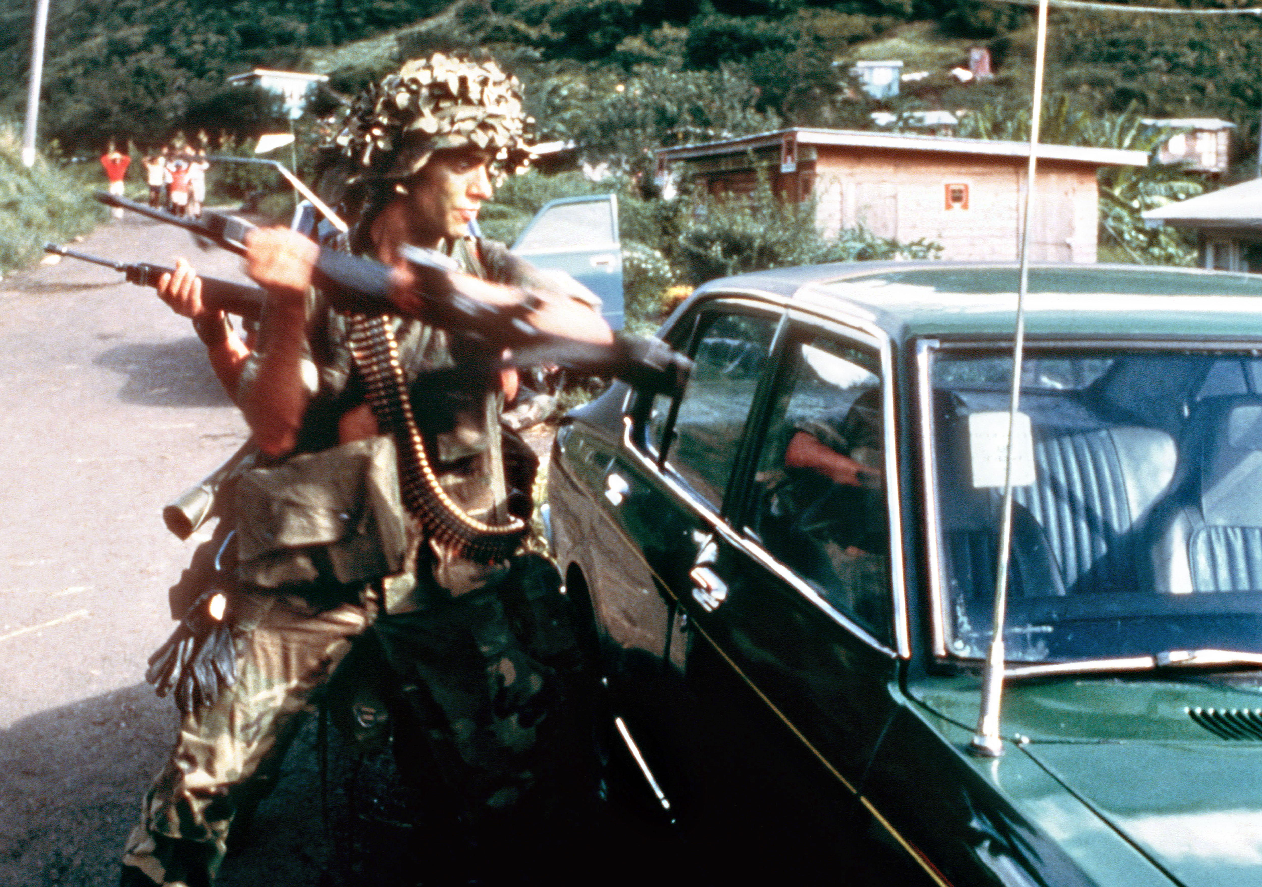 US 82nd Airborne Division soldiers use their rifle butts to break into a car to check for bombs during the Invasion of Grenada