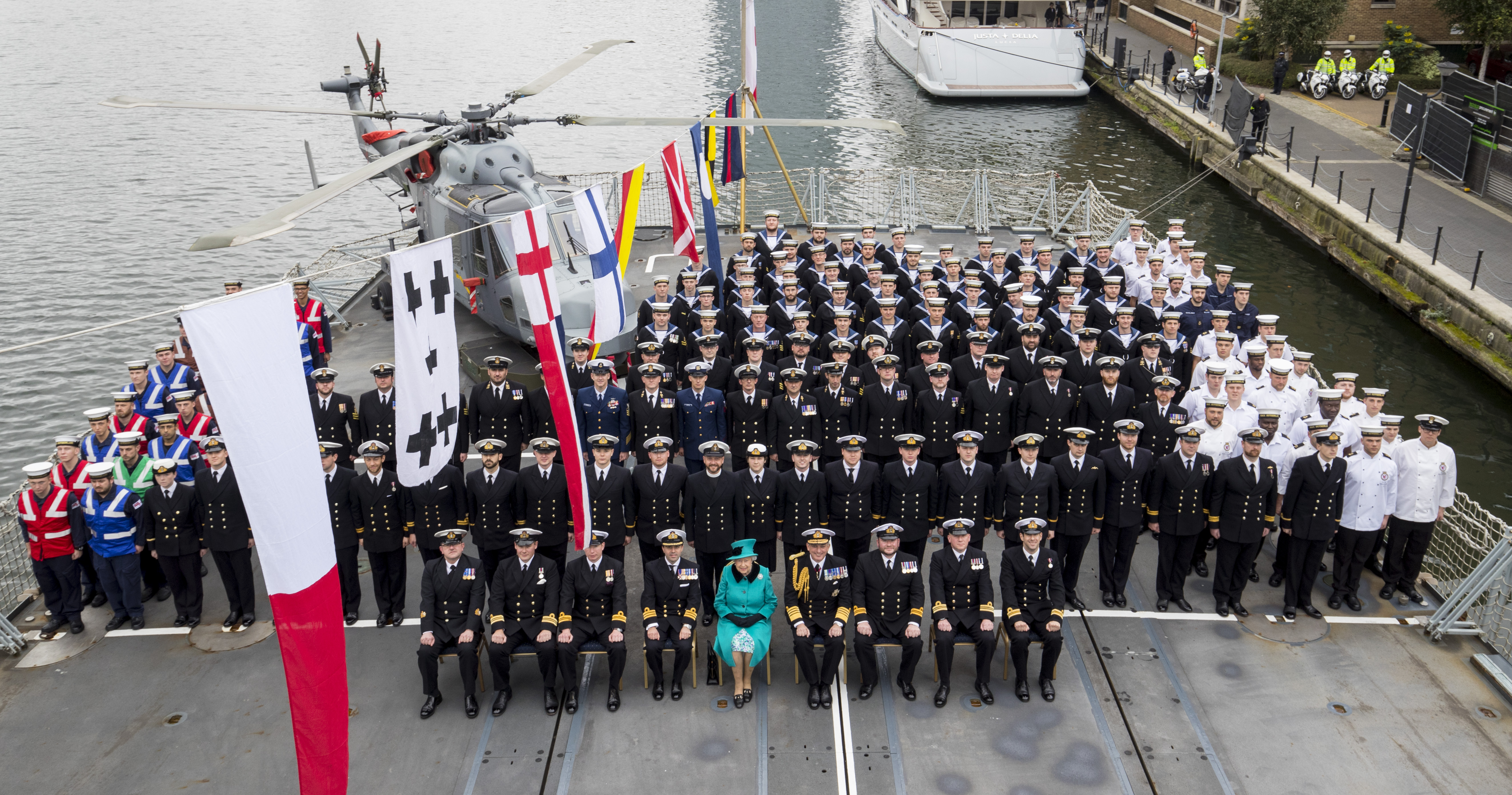 Image shows HRH The Queen with HMS Sutherland’s ships company and the First Sea Lord on the ships flightdeck.