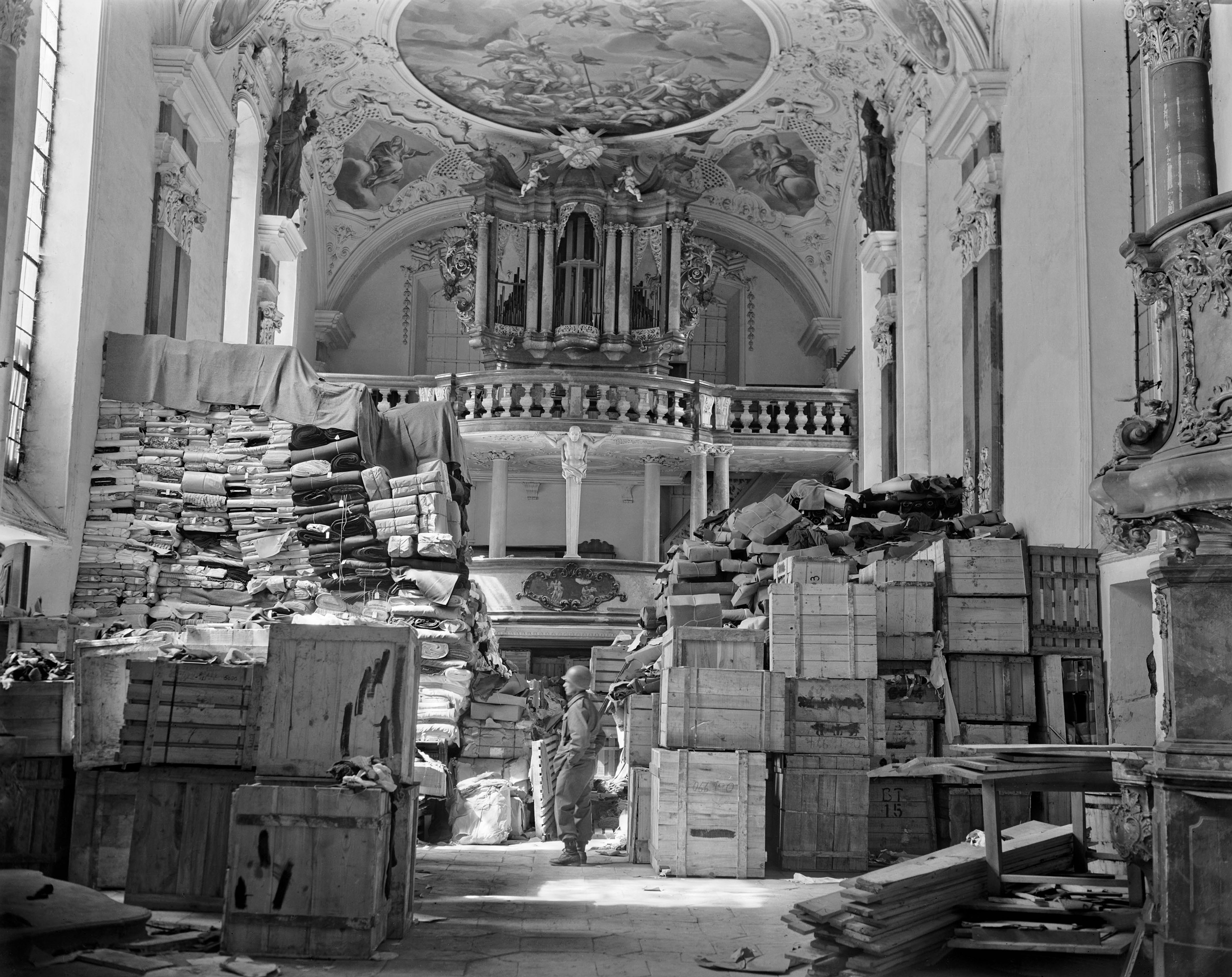 A US soldier from the Third Army views stacks of jewish owned art looted by the Nazi hidden in a church April 24, 1945 in Ellingen, Germany