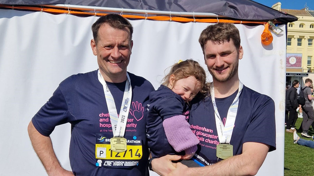 David Lynham, holds his daughter while stood next to his father at the Brighton marathon CREDIT David Lynham