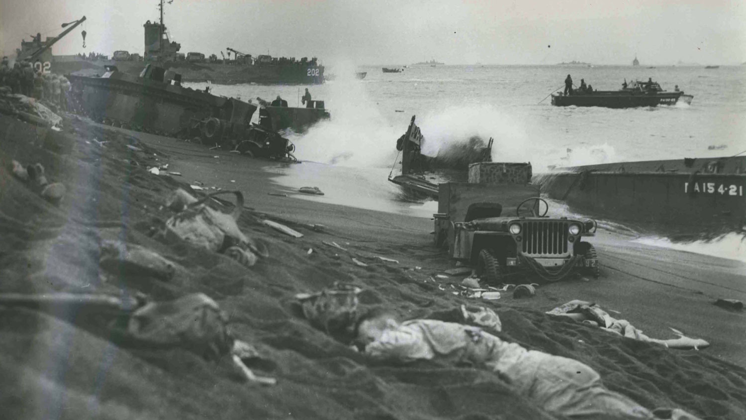 Dead US Marines lie on the Iwo Jima beach with Jeeps and smashed landing craft seen in the distance CREDIT National Archives and Records Administration
