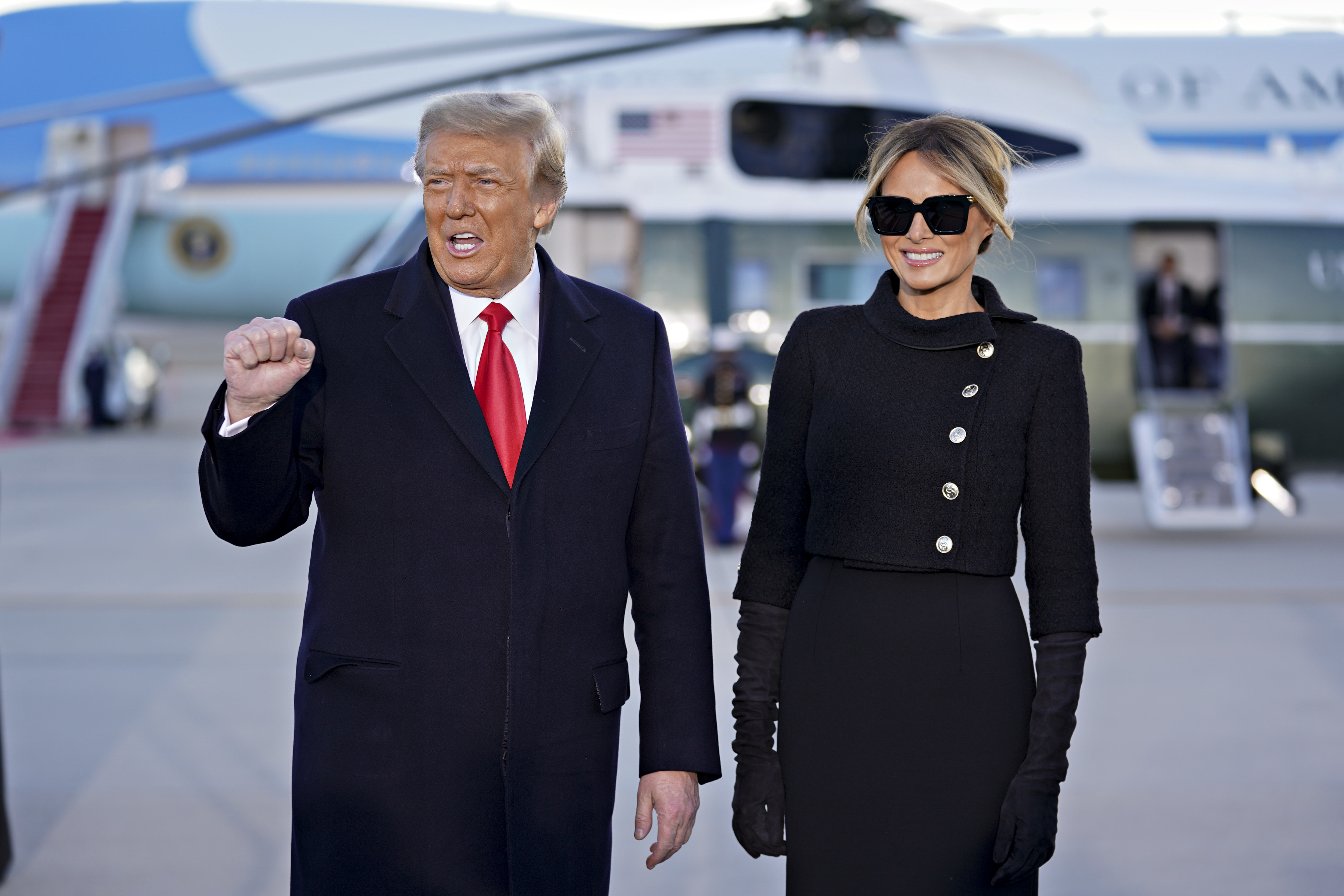 Donald Trump pumps fist with Melania Trump beside him as they arrive at Joint Base Andrews, Maryland, for farewell ceremony (Picture: PA)