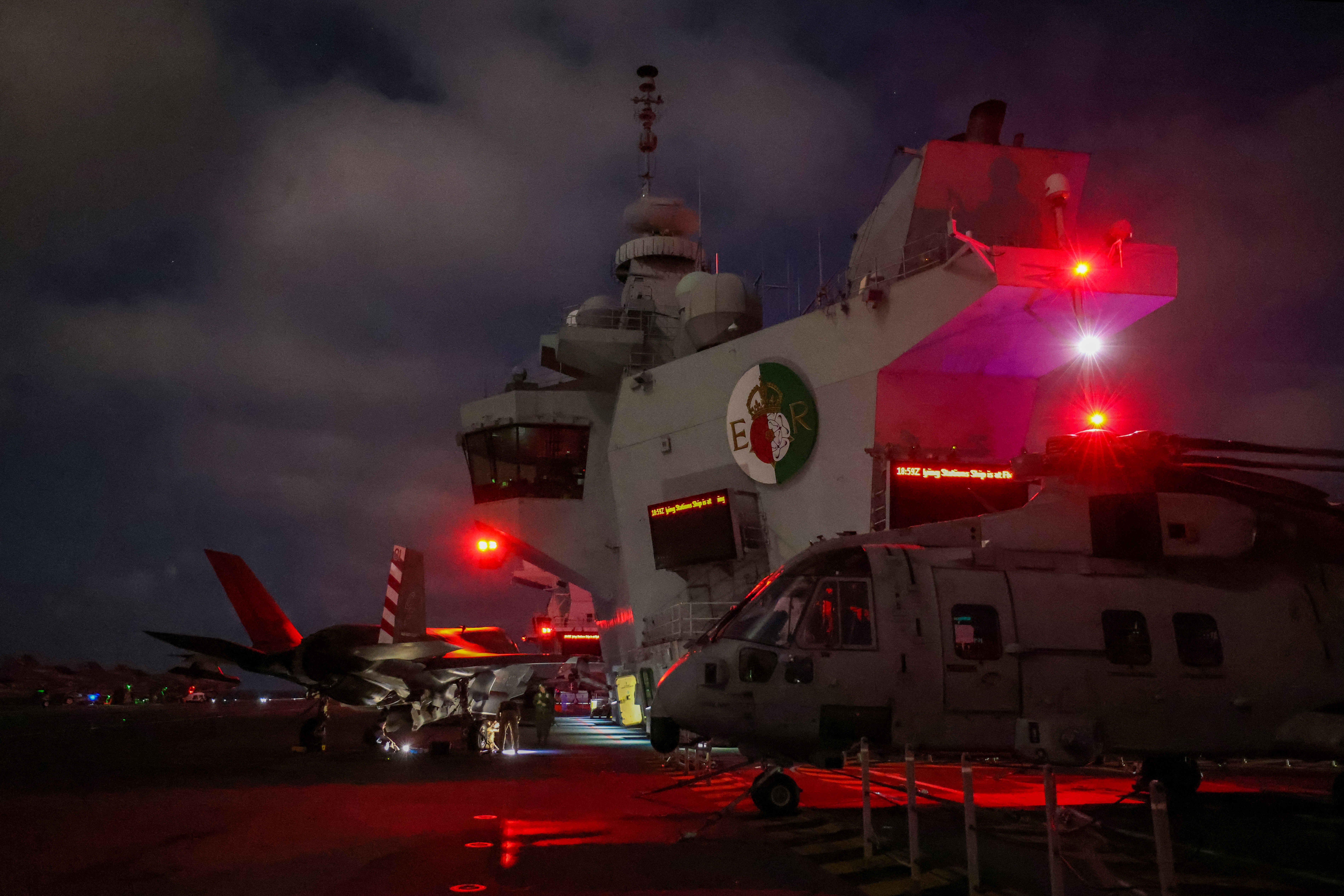 A Merlin Mk4 and an F35B Lightning on the flight deck of HMS Queen Elizabeth during her replenishment.