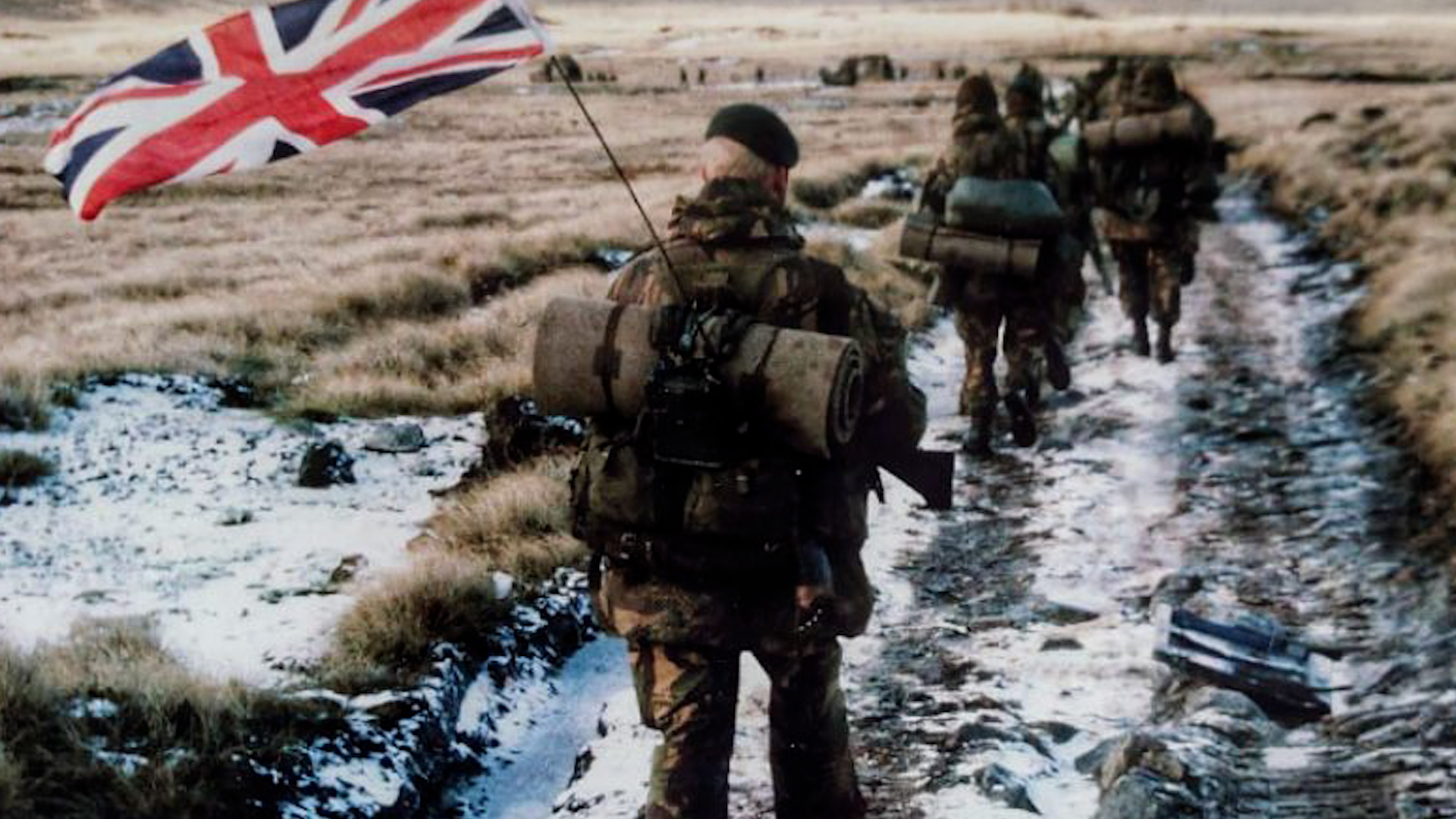 Falkland-Islands-Falklands-Conflict-Yomper-Yomp-Commandos-40-Commando-Anti-Tank-Troop-march-towards-Port-Stanley-1982-Union-Jack-Flag-CREDIT-Pete-Holdgate
