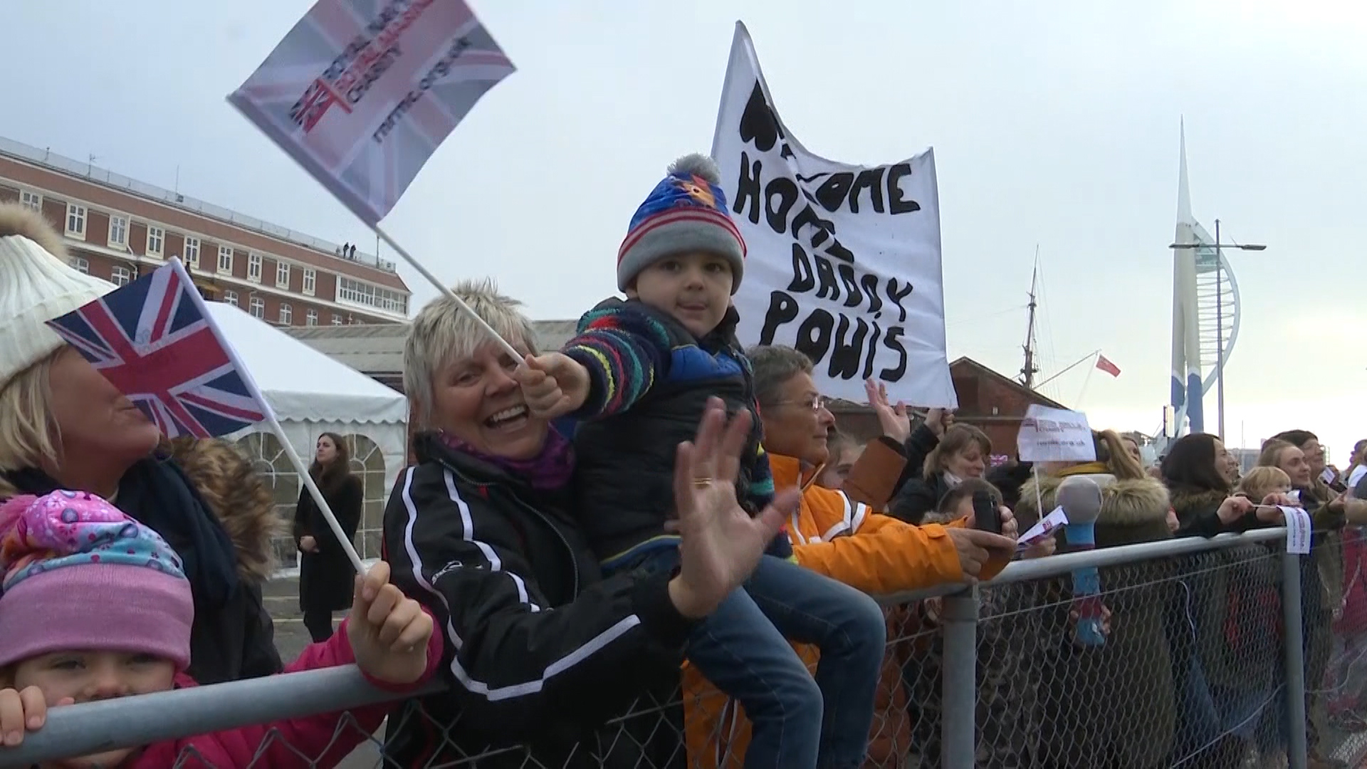 Families and friends held up signs and flags ahead of the ship's arrival. 