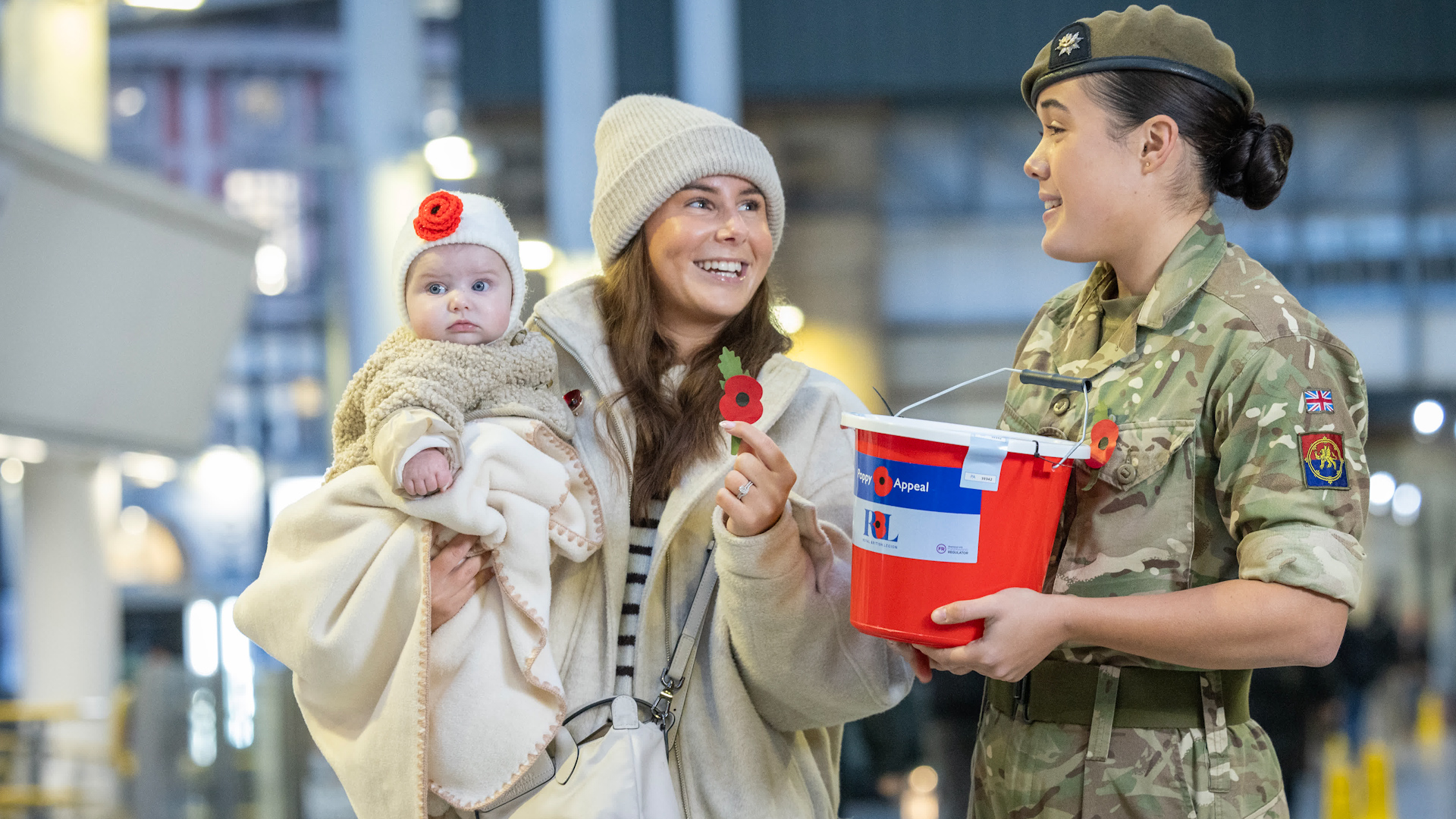 Five-month-old Florence Furness and her mother Ashton Furness with poppy sellers, during the Royal British Legion Poppy Appeal 2026 national launch at Manchester Victoria Station (Picture: Royal British Legion)