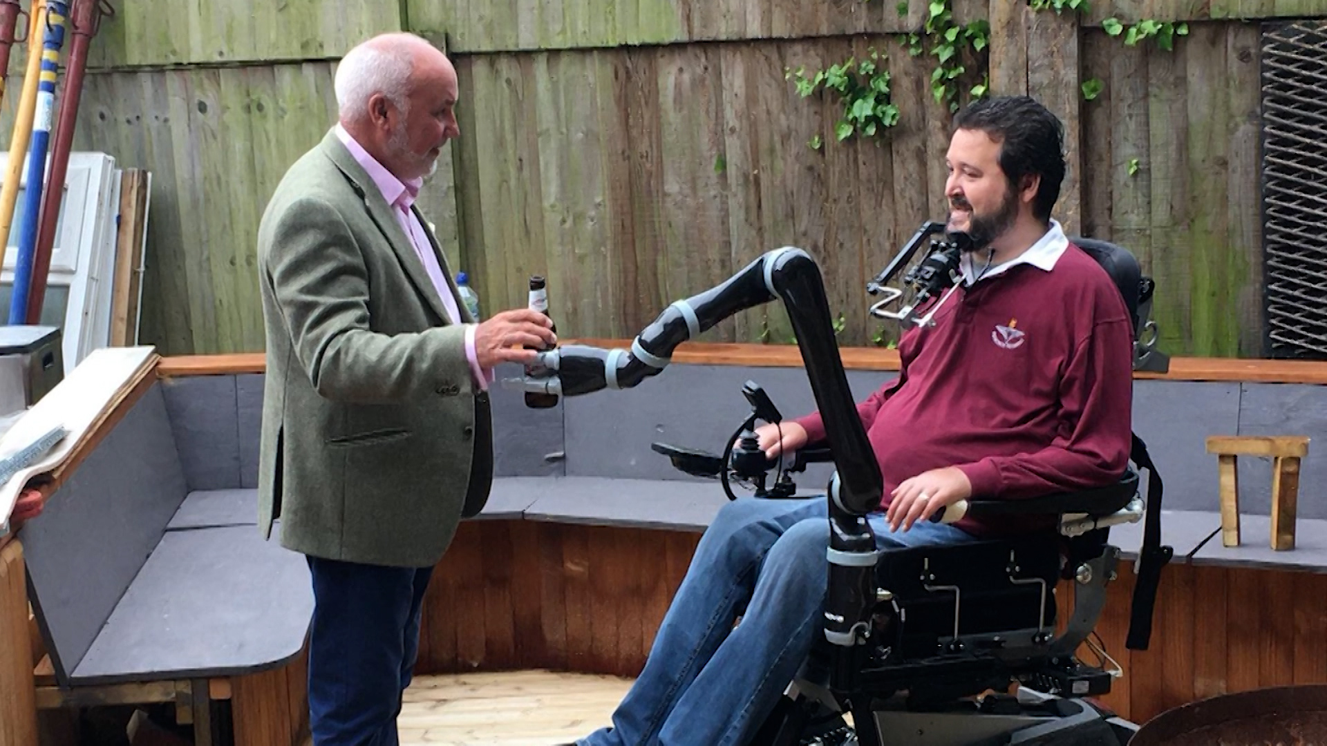 Former paratrooper Jon Noble using new robotic arm to give his dad a beer.