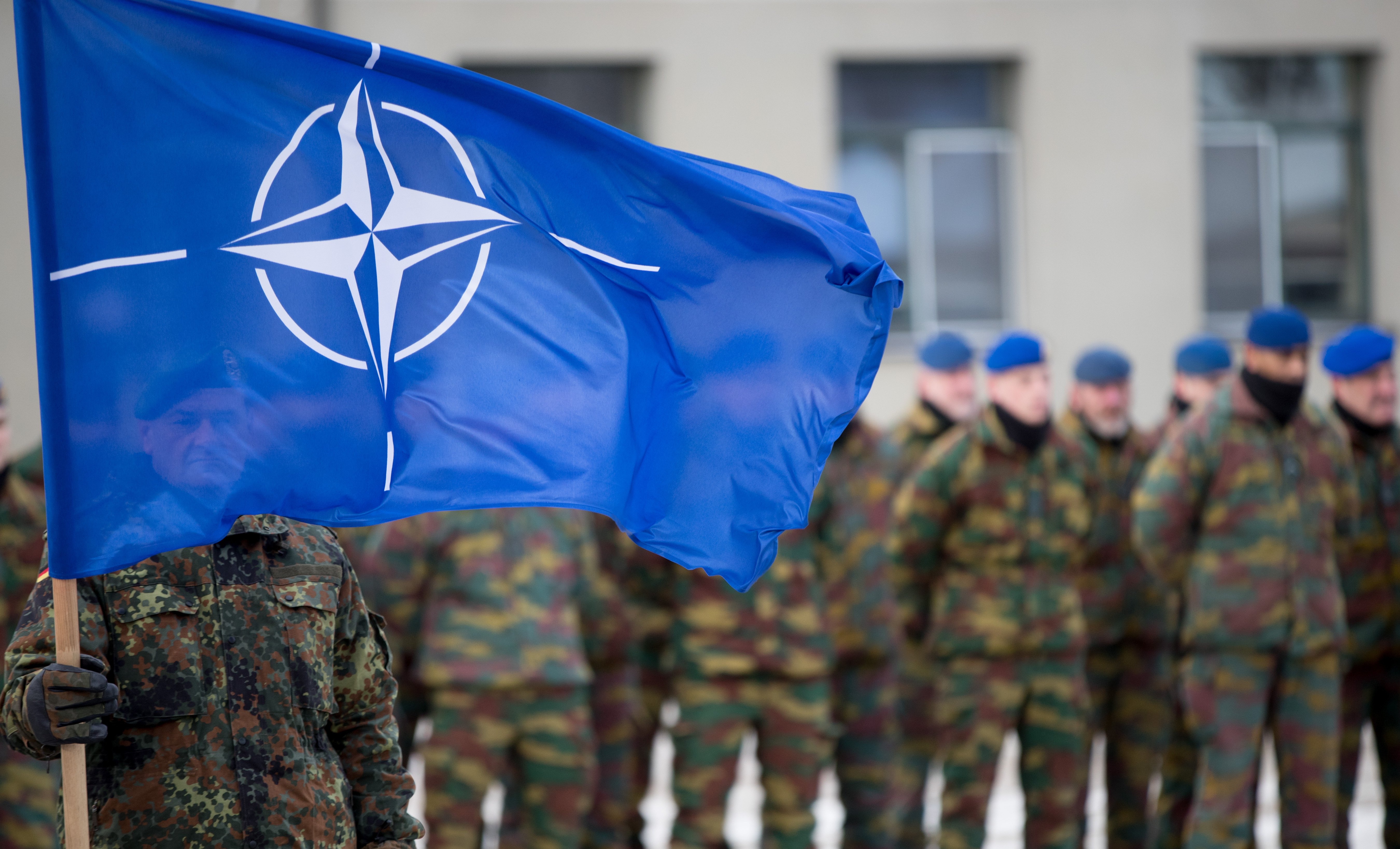 German soldiers hoists the NATO flag to greet the German minister of Defence