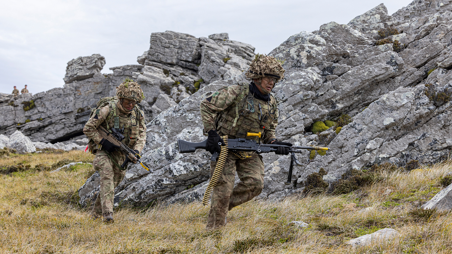 The gun group moves into position as members of the directing staff look on