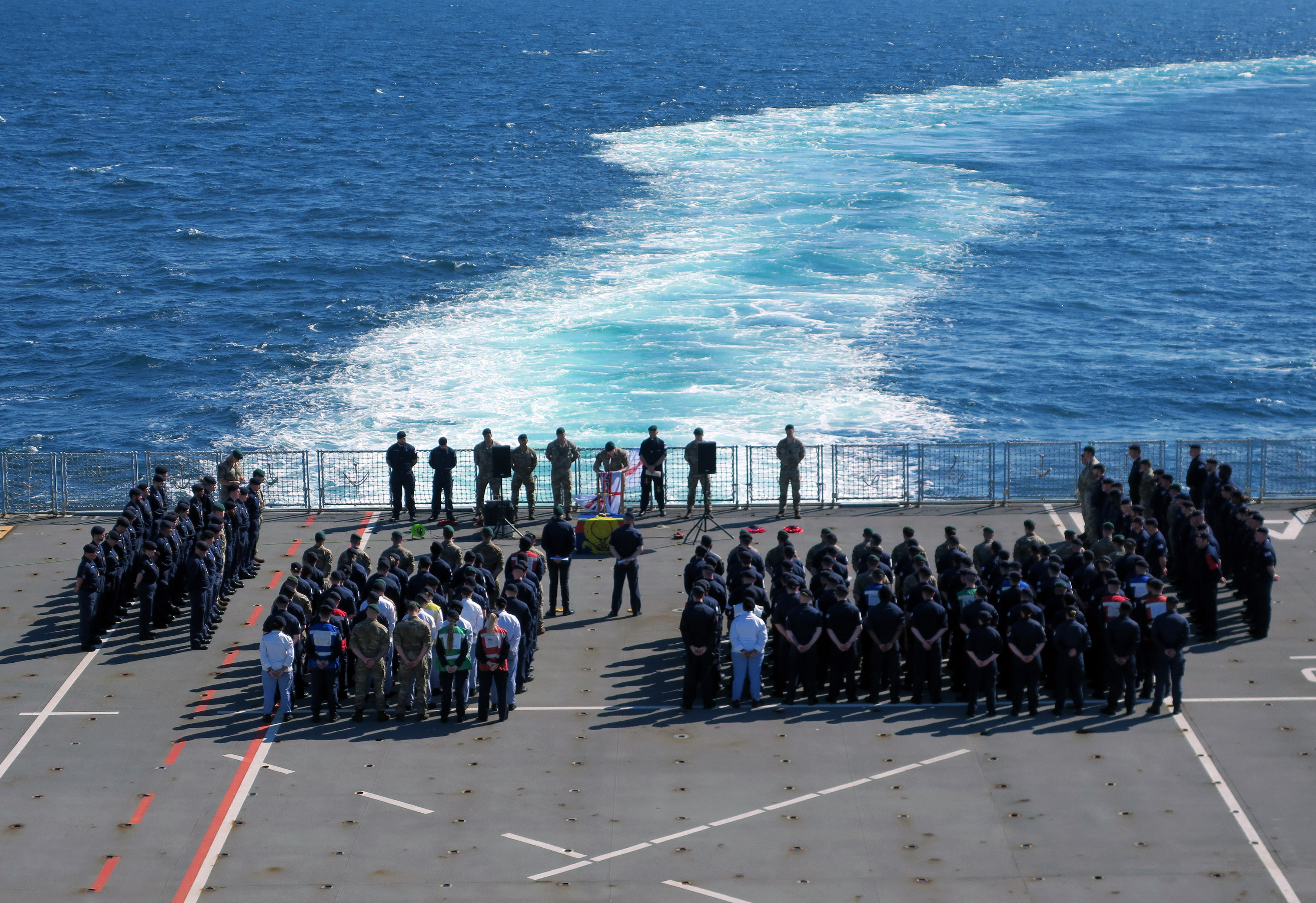 HMS Albion's sailors and marines attend the service for Foxtrot 4 on the flight deck 
