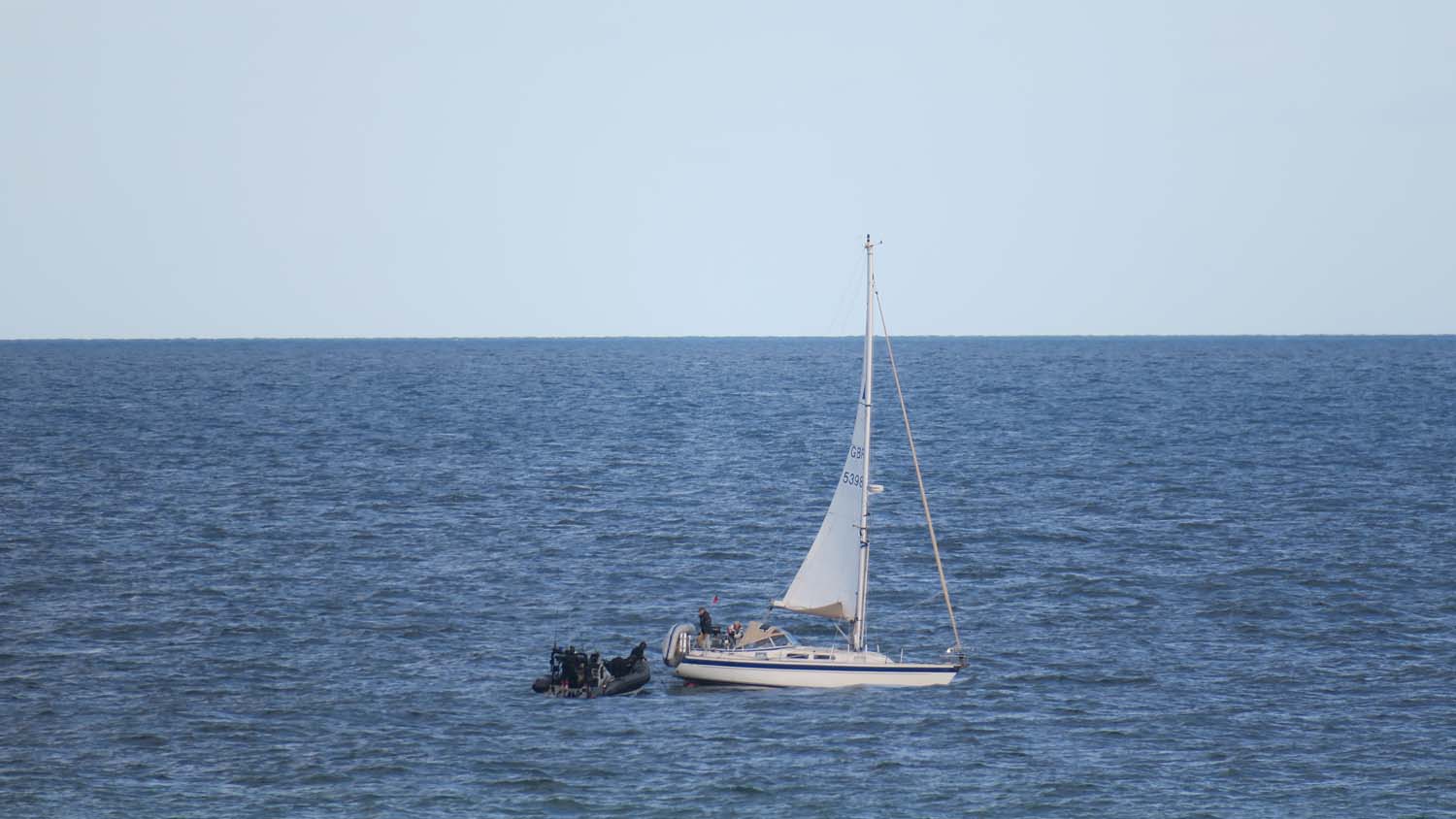HMS Dragon personnel assist the stranded yacht (Picture: Royal Navy).