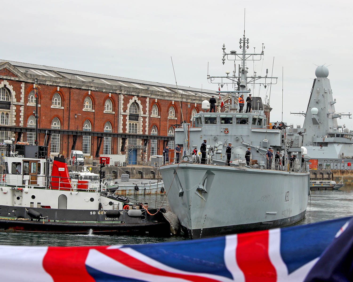 Sailors lined the deck on HMS Ledbury as she was towed into Portsmouth Naval Base (Picture: Royal Navy).