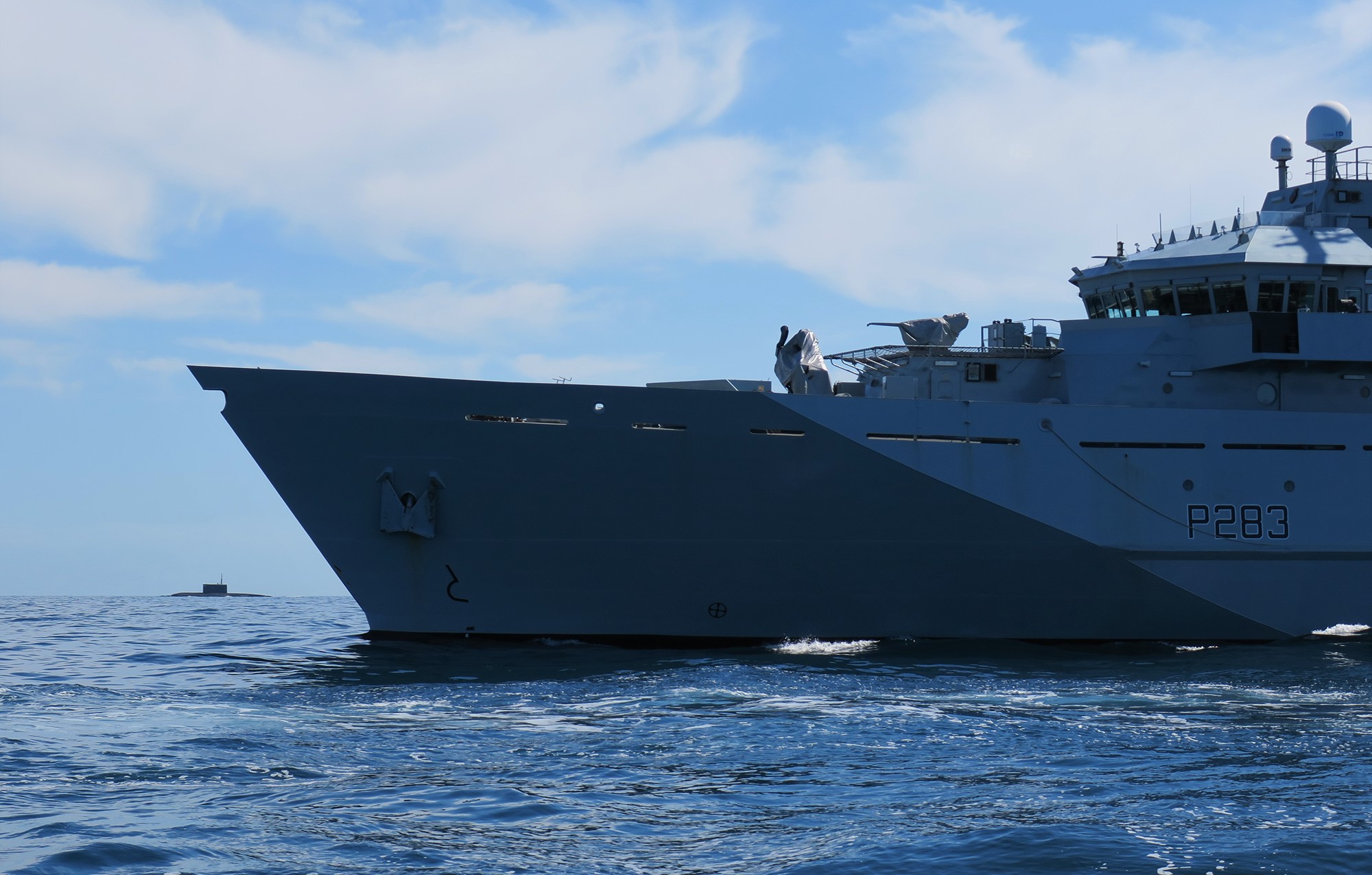 HMS Mersey is pictured with the Russian submarine in the background (Picture: Royal Navy).