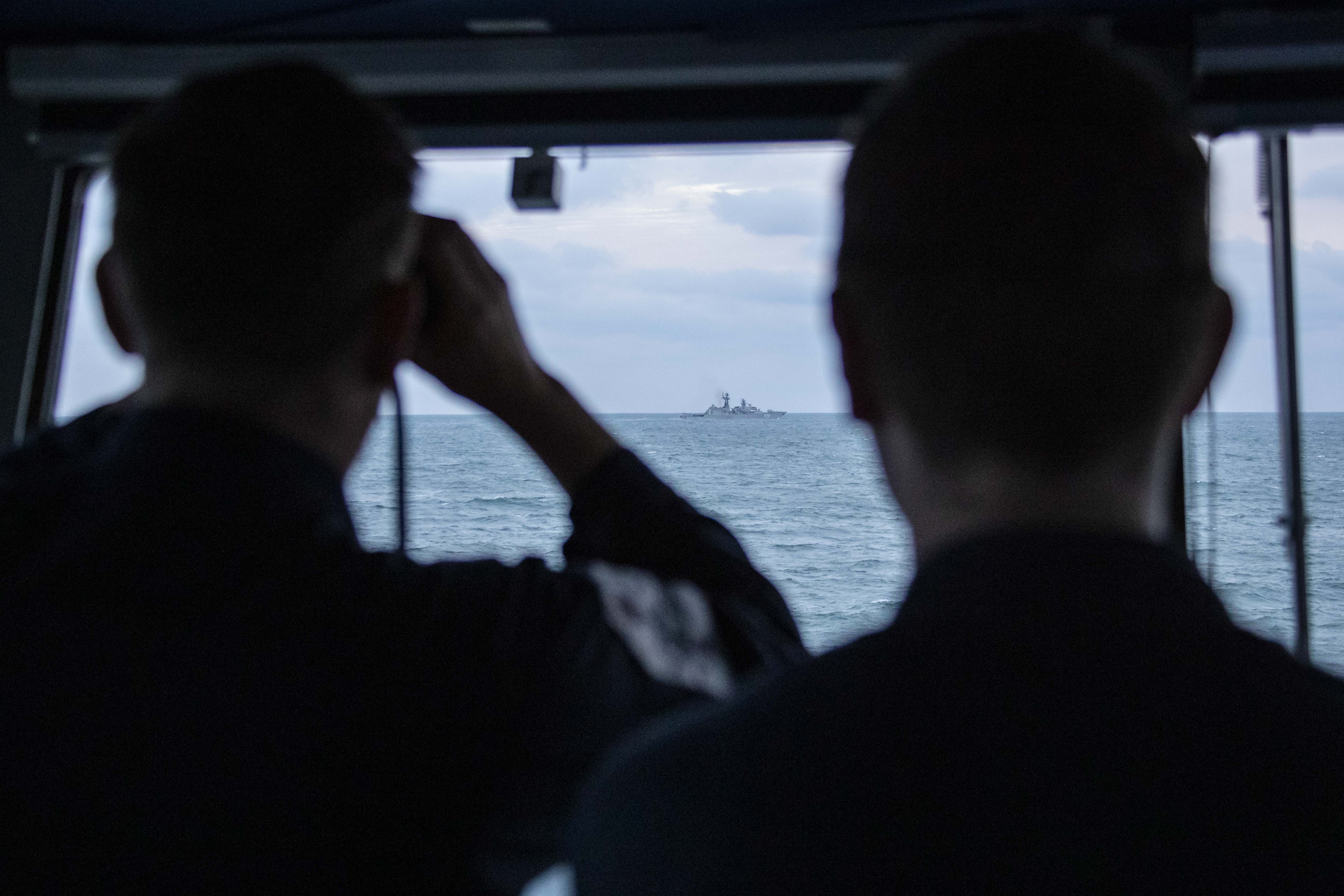 Crew from HMS Mersey keep a close eye on a Russian vessel in the distance (Picture: Royal Navy).