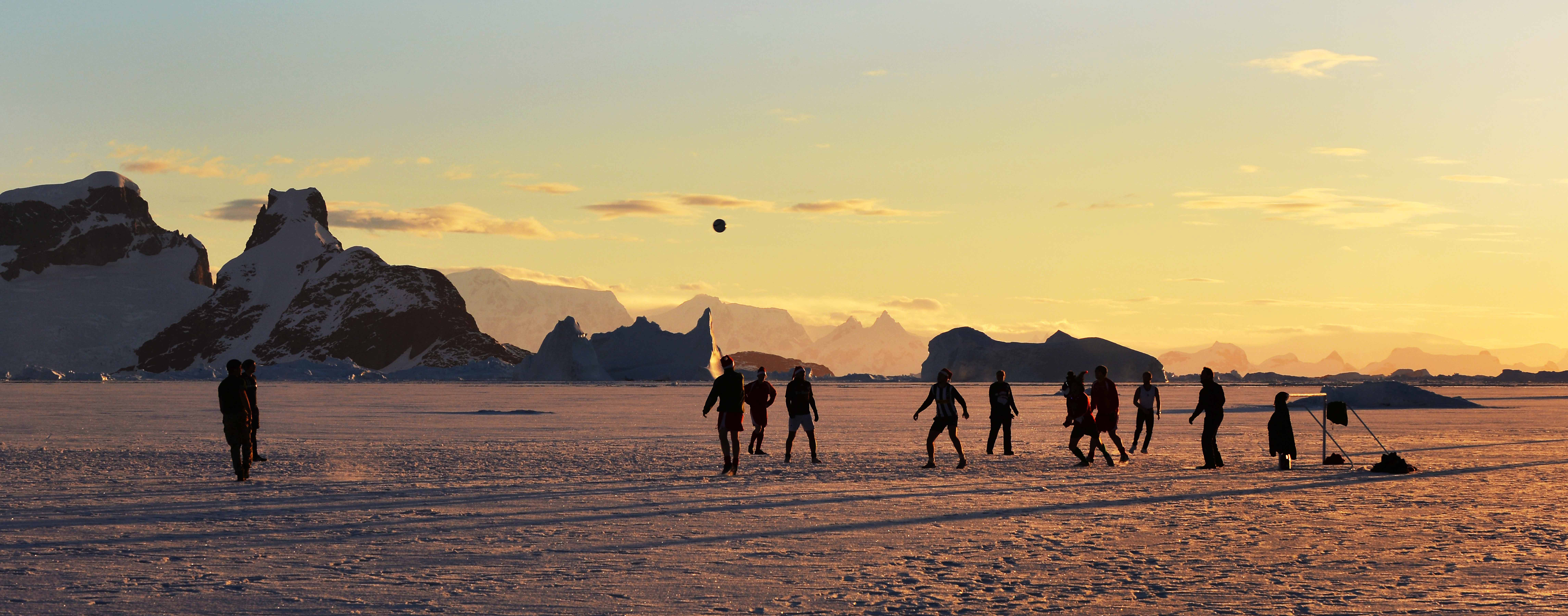 Members of HMS Protectors Ships Company play football on the ice as the sun sets in Antarctica Credit Defence Imagery Royal Navy LA(Phot) Vicki Benwell
