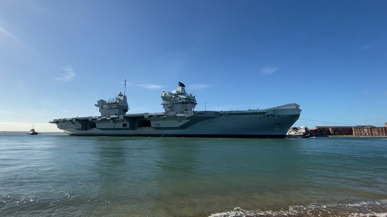 HMS Queen Elizabeth returns to Portsmouth with tugs