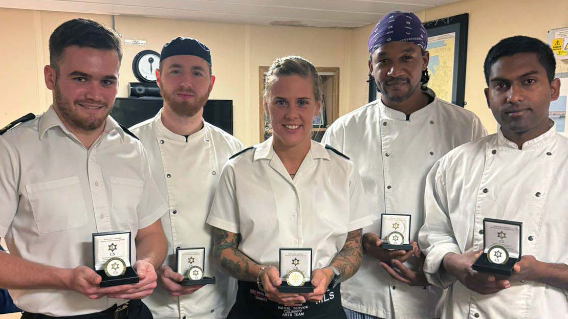 HMS Trents catering team with the Fleet Caterers coin in recognition of their efforts CREDIT Royal Navy