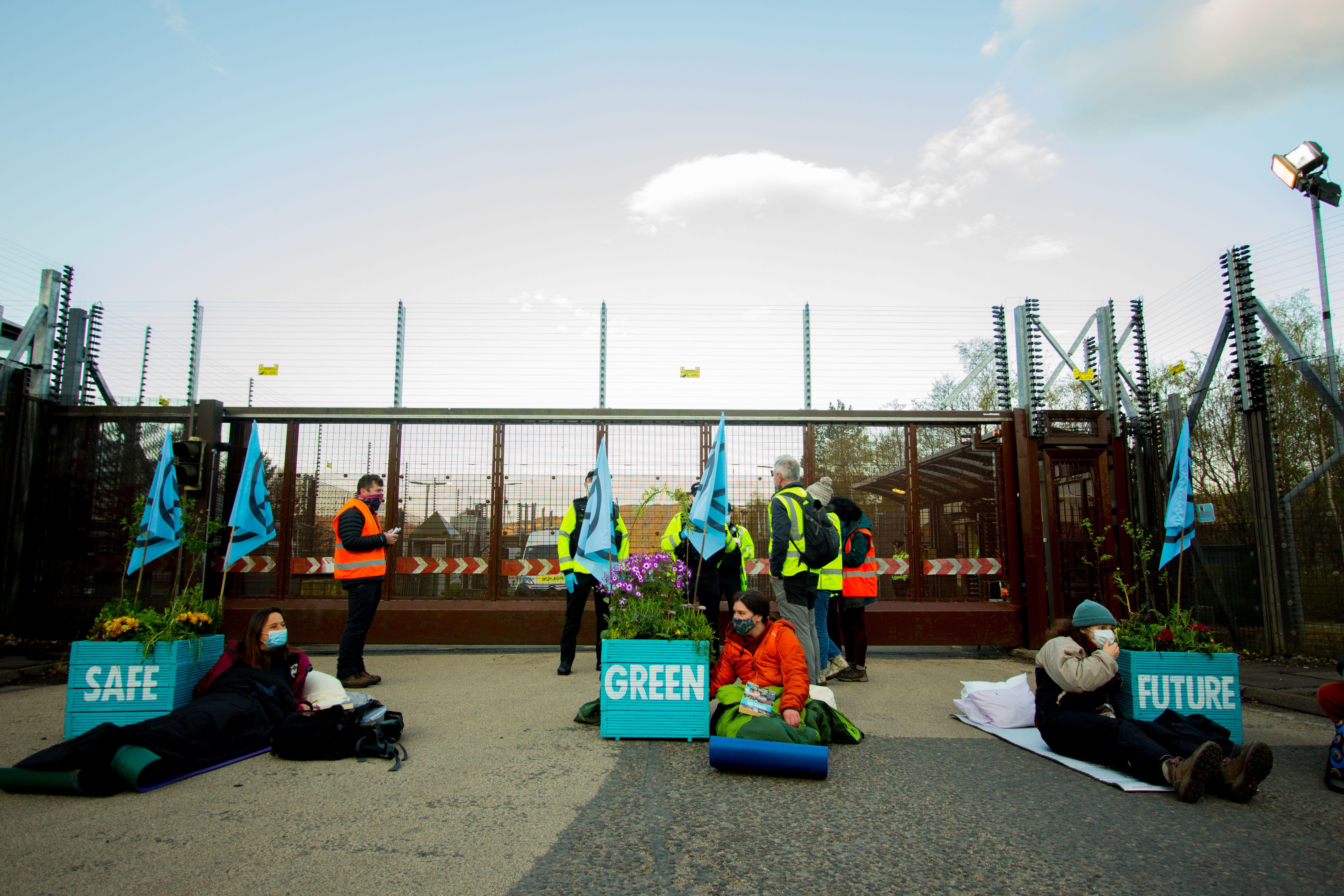 Extinction Rebellion protestors locked themselves onto large plant pots outside the base (Picture: PA Images/Alamy Stock Photo).